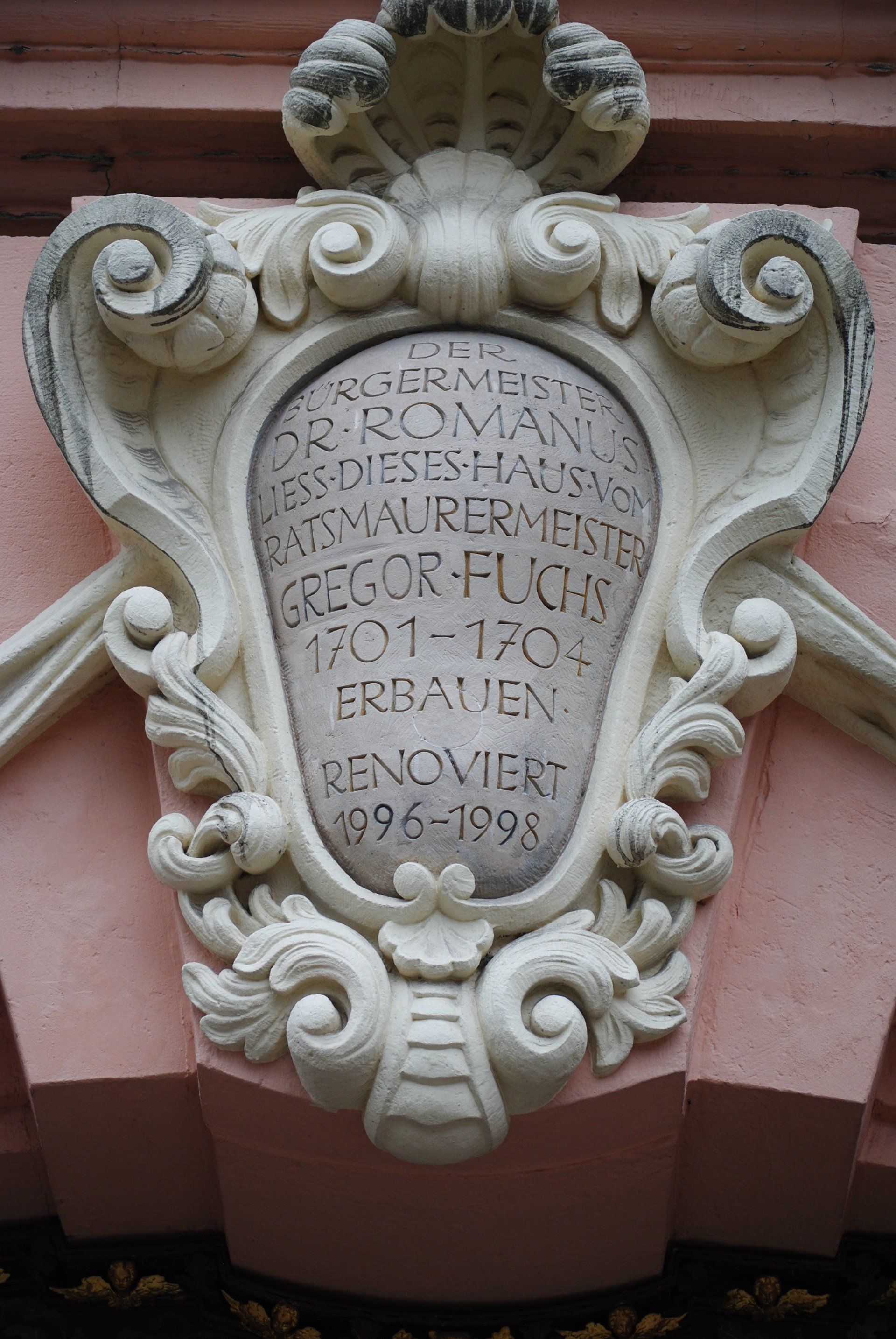 A plaque on the side of a building that says gregor puck on it.