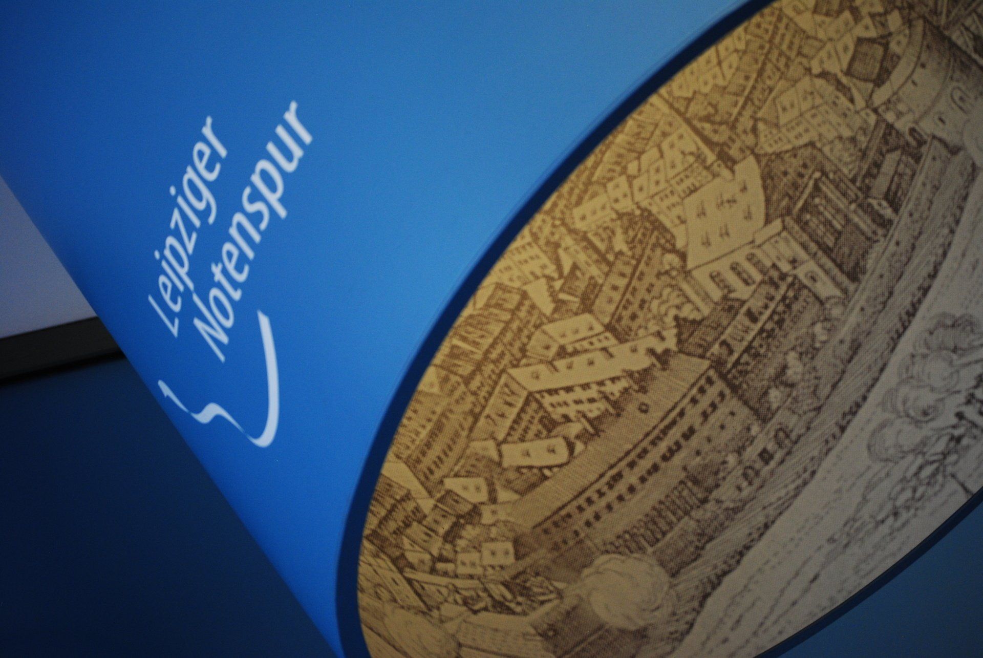 A blue cylinder with a drawing of a city on it