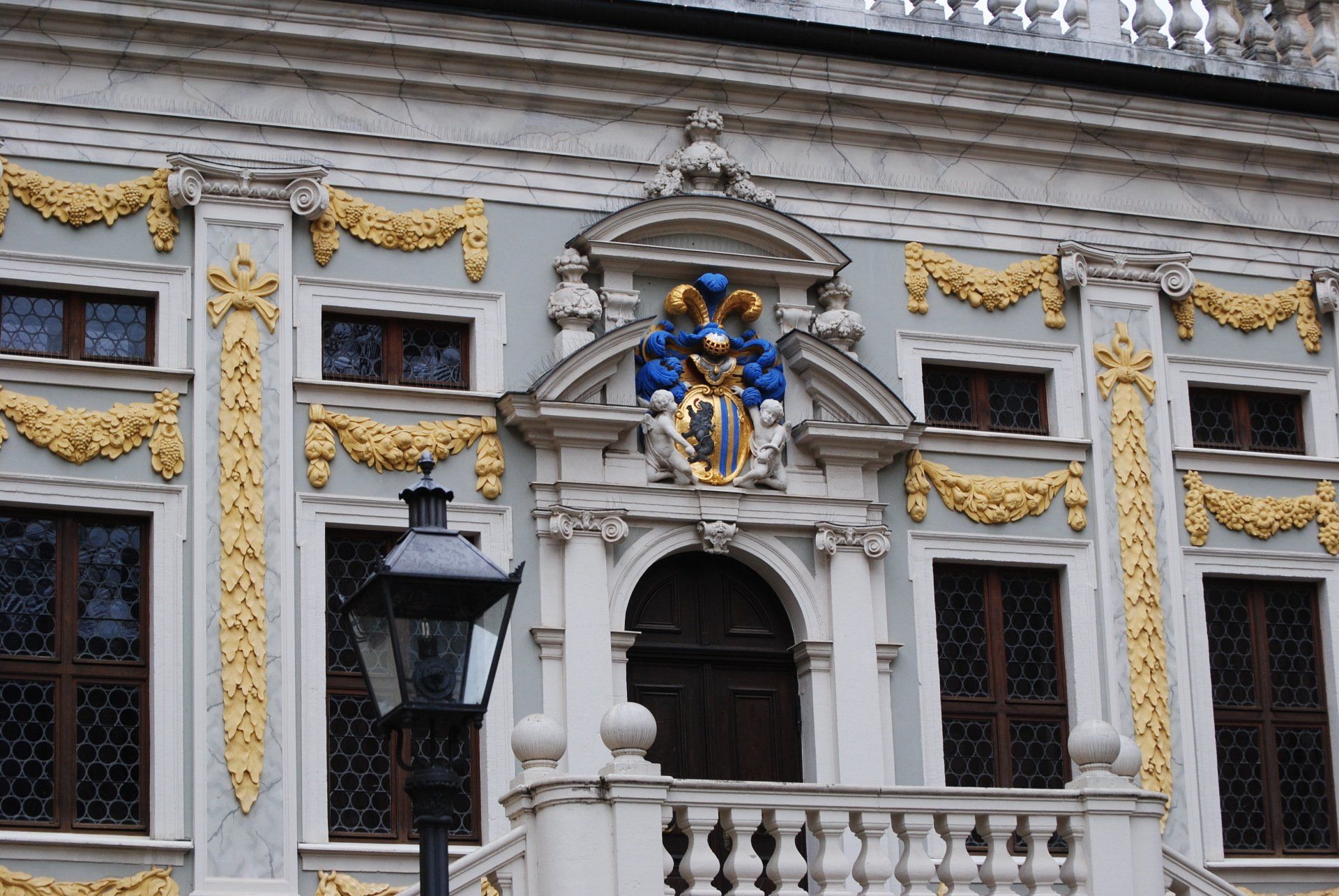 A building with a balcony and a coat of arms on it
