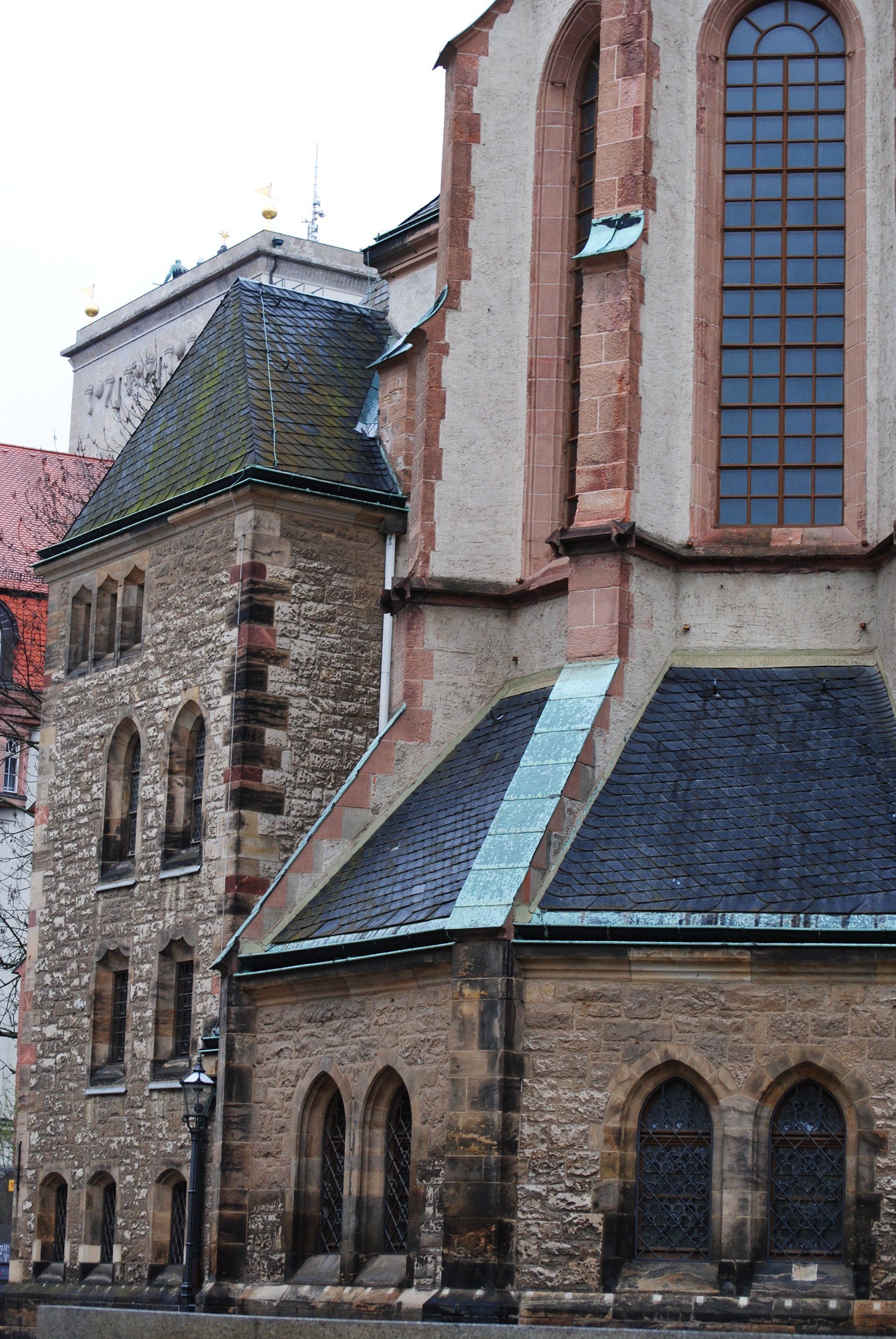 A large stone building with a large window on the side of it.