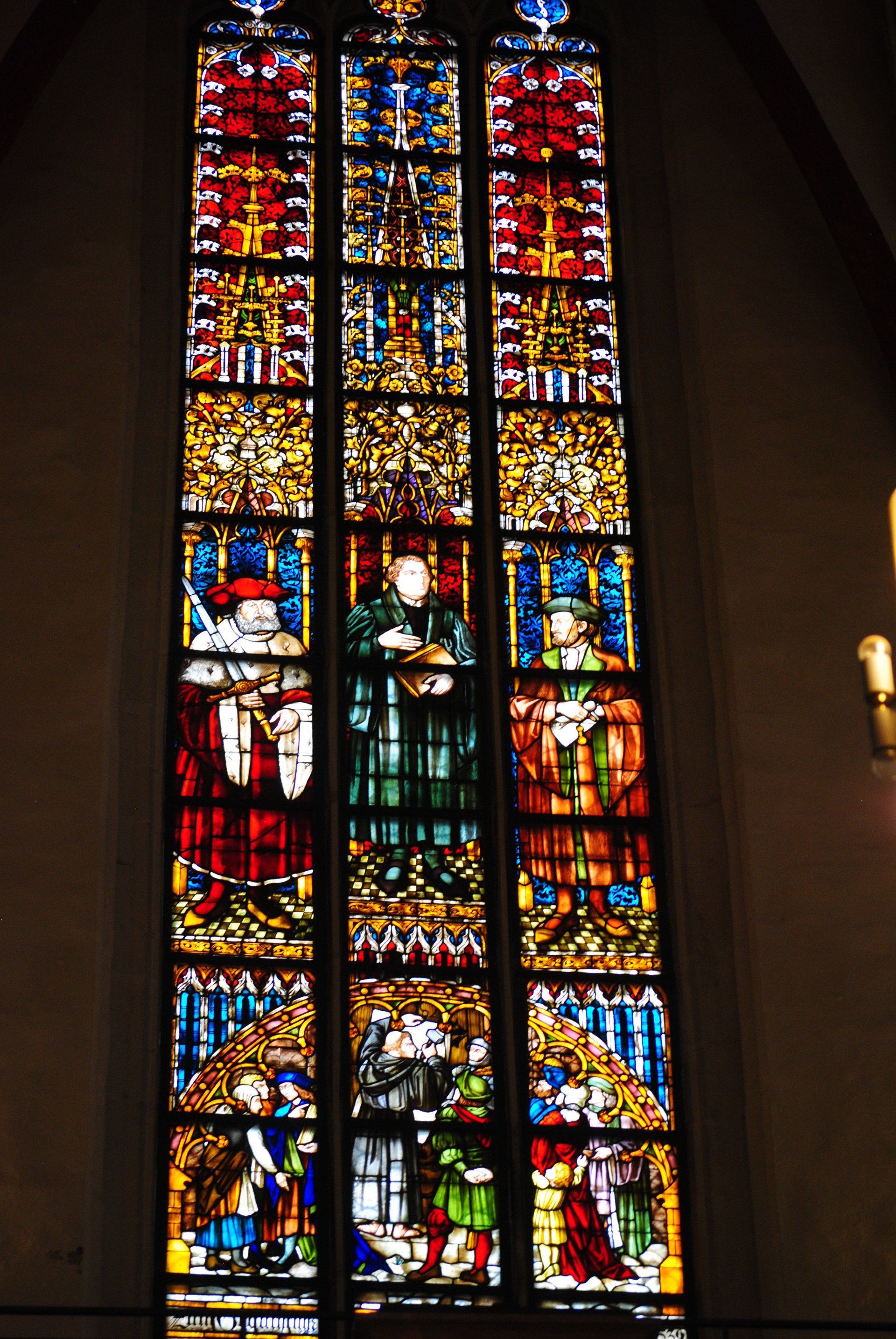 A stained glass window in a church with the word jesus on it