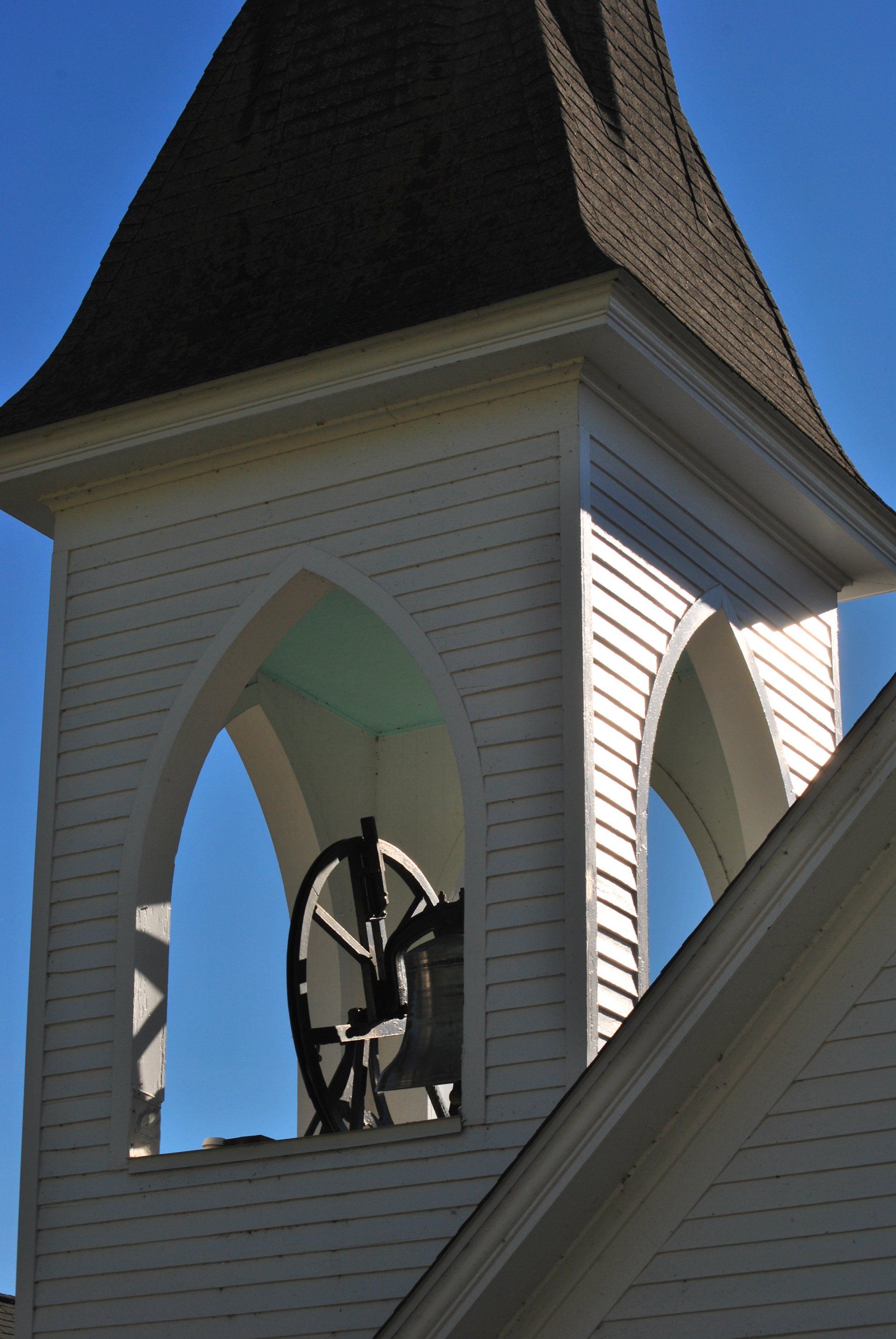 A bell tower on top of a building with a blue sky in the background