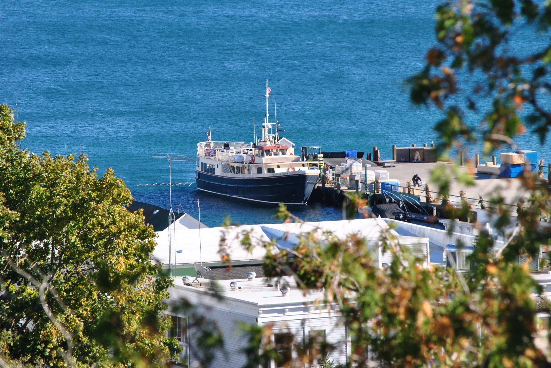 A large boat is docked in the water near a dock.