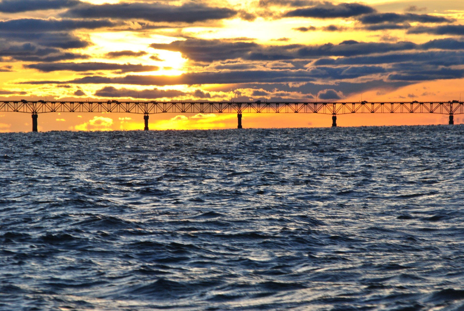 A bridge over a body of water at sunset.