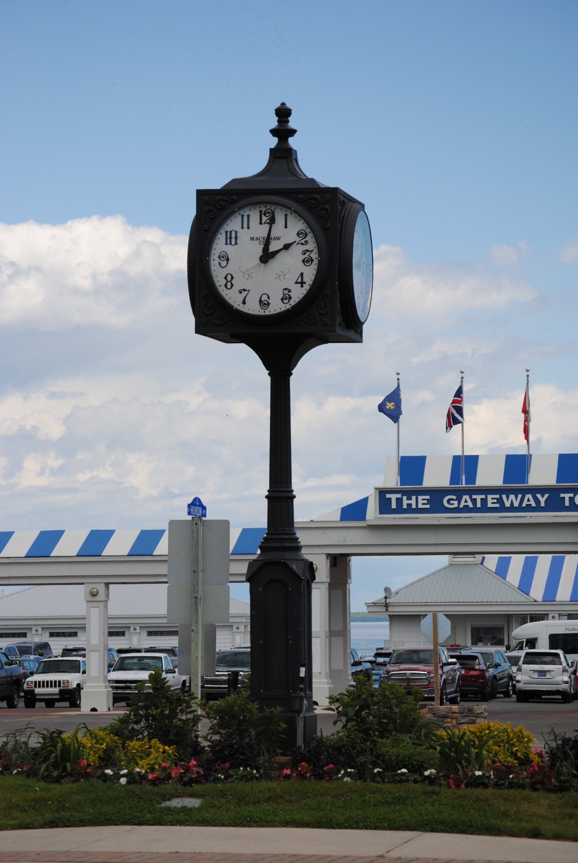 A clock in front of a building that says the gateway
