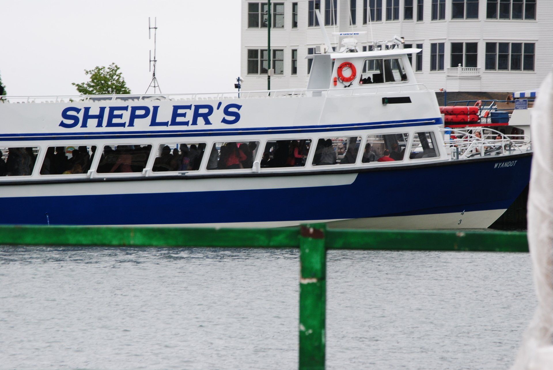 A shepler 's boat is docked in front of a building