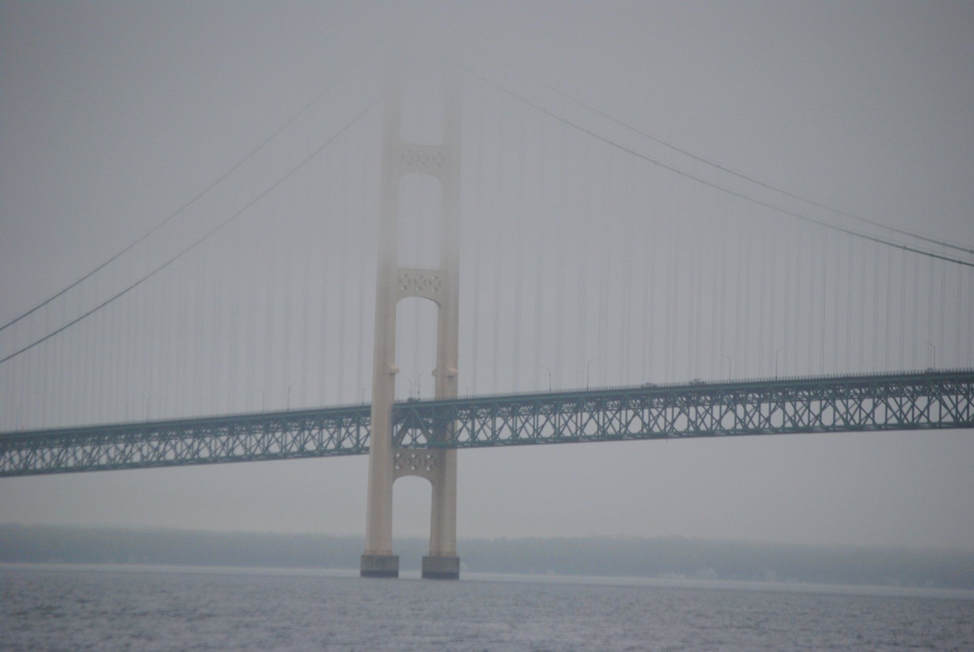 A bridge over a body of water on a foggy day.