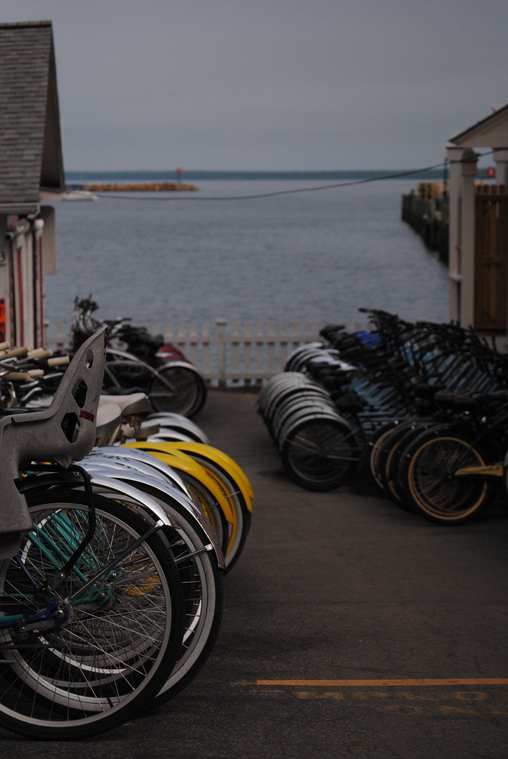 A bunch of bikes are parked on the side of the road