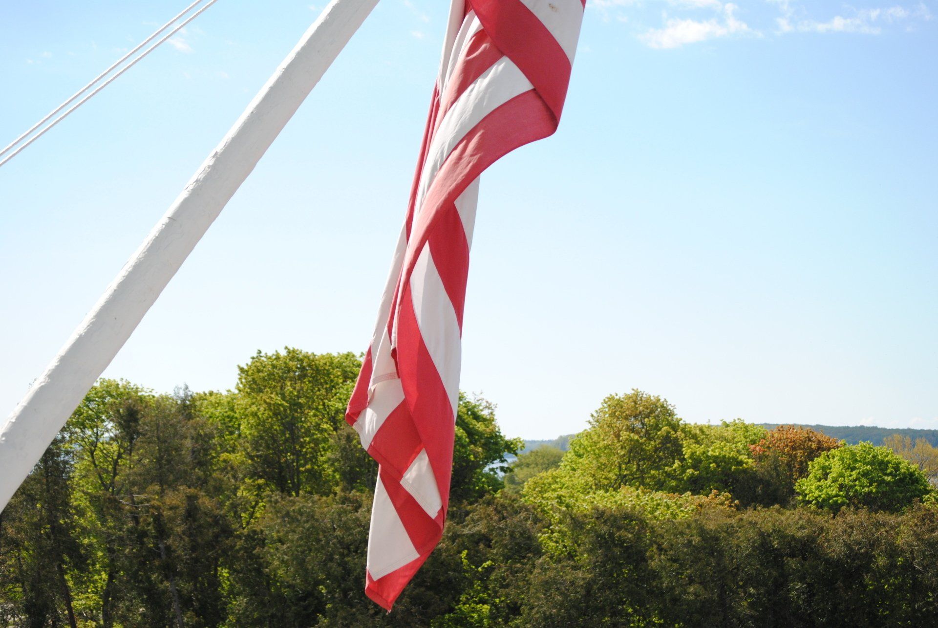 A red white and blue flag is flying in the wind
