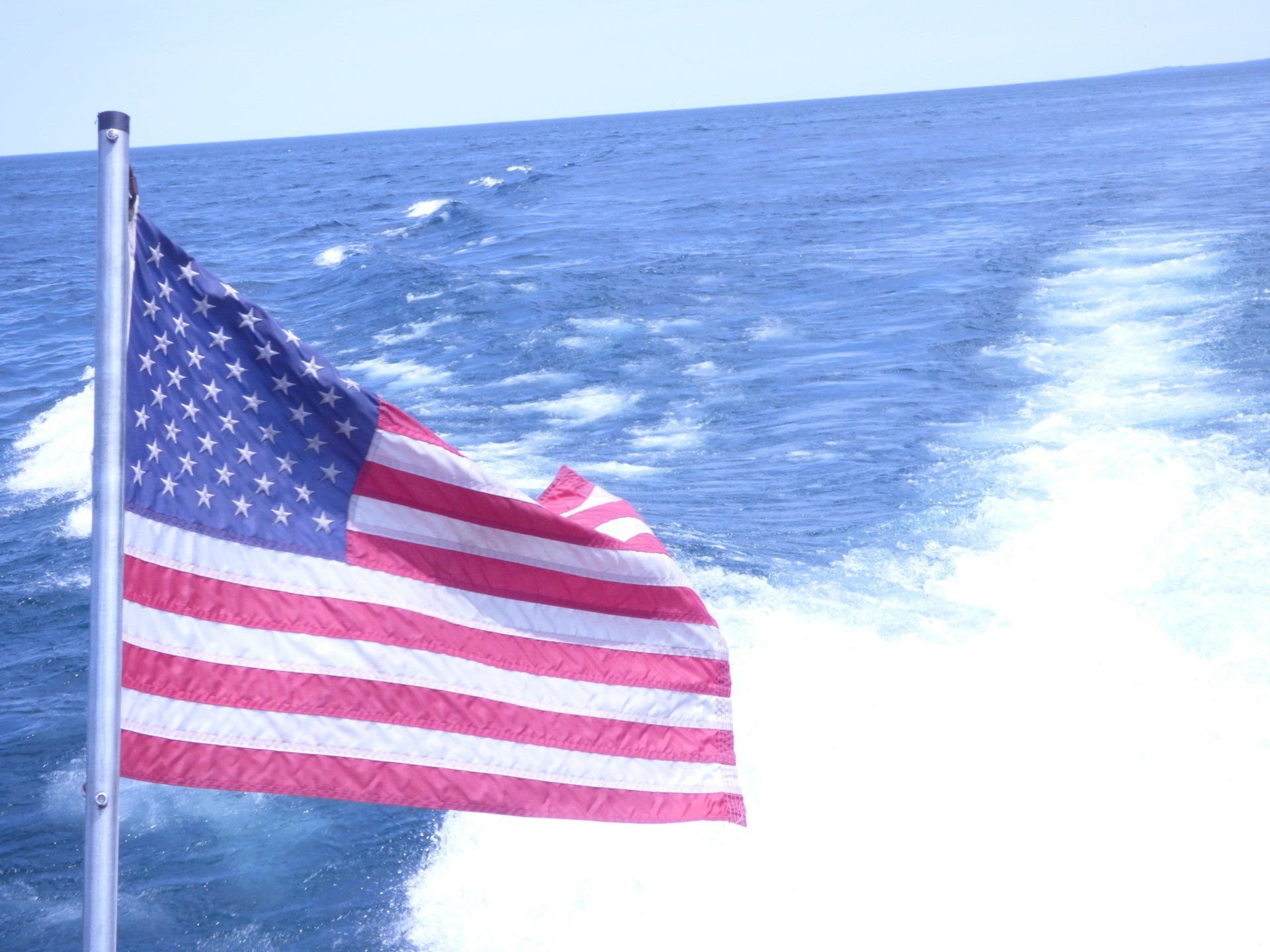 An american flag is flying in the ocean