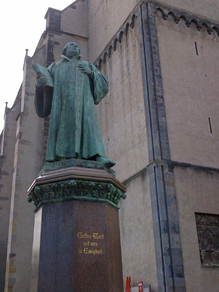 A statue of a man standing in front of a building