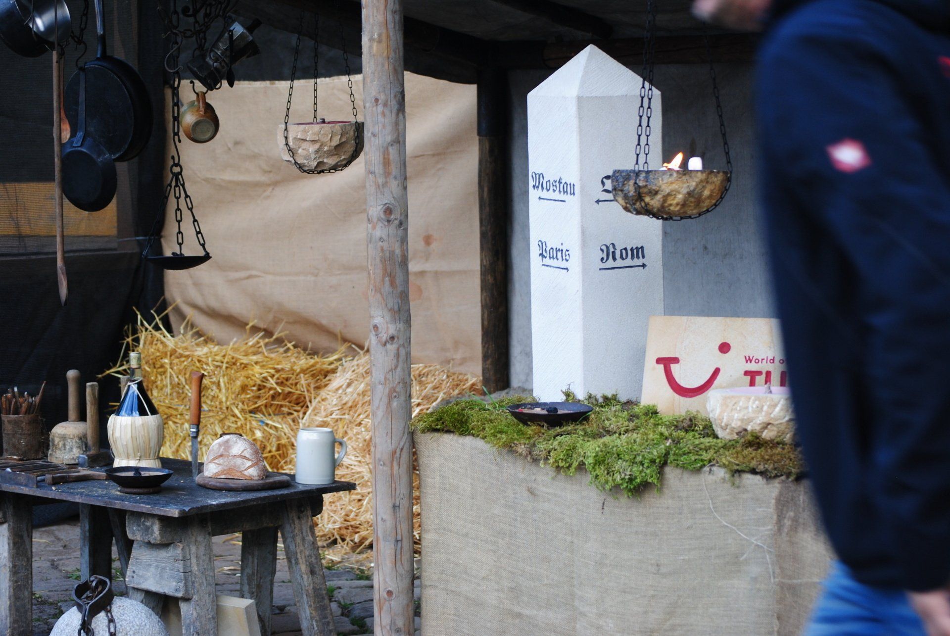 A man in a blue jacket walks past a sign that says tui