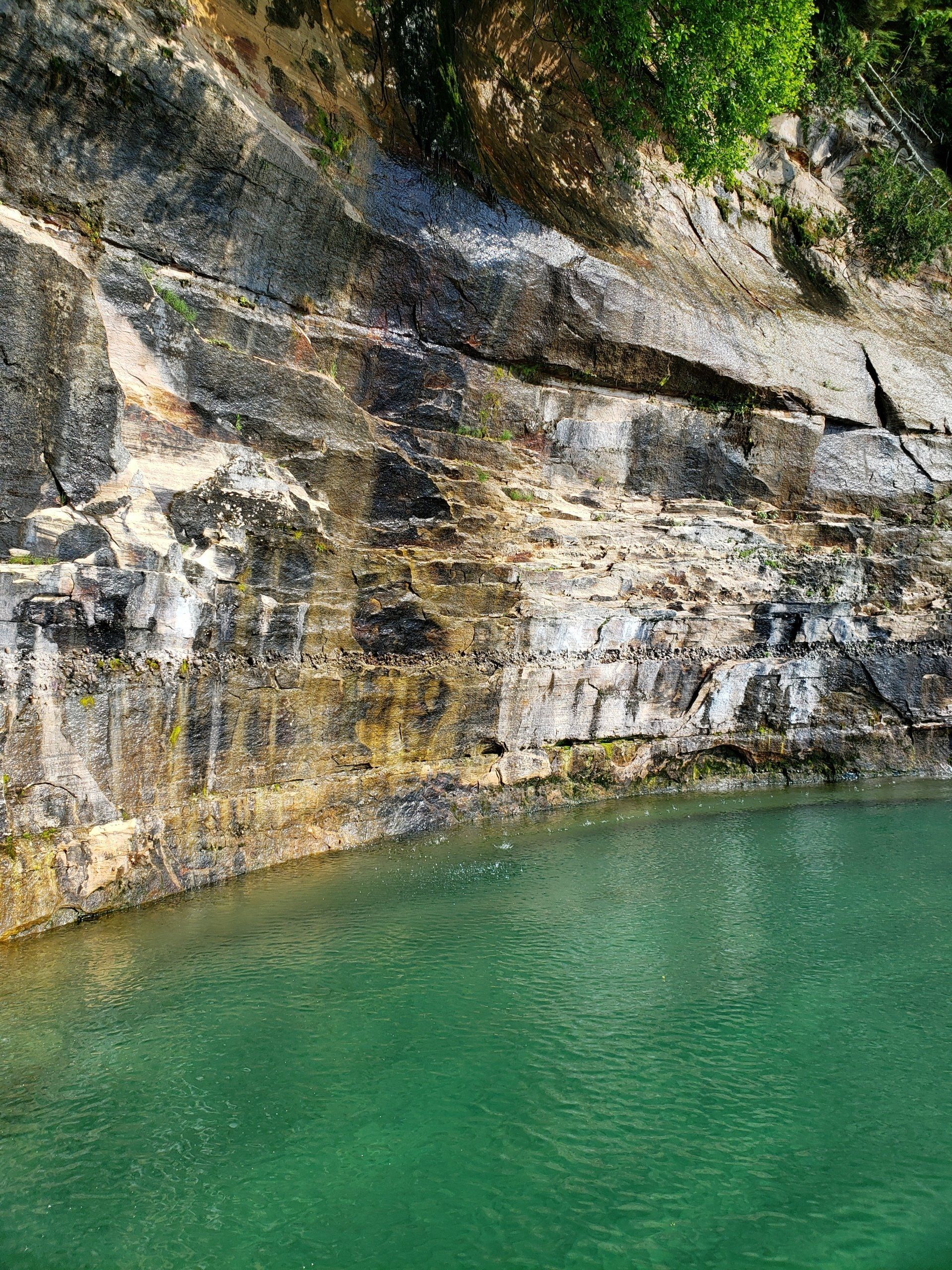 A large body of water surrounded by rocks and trees.