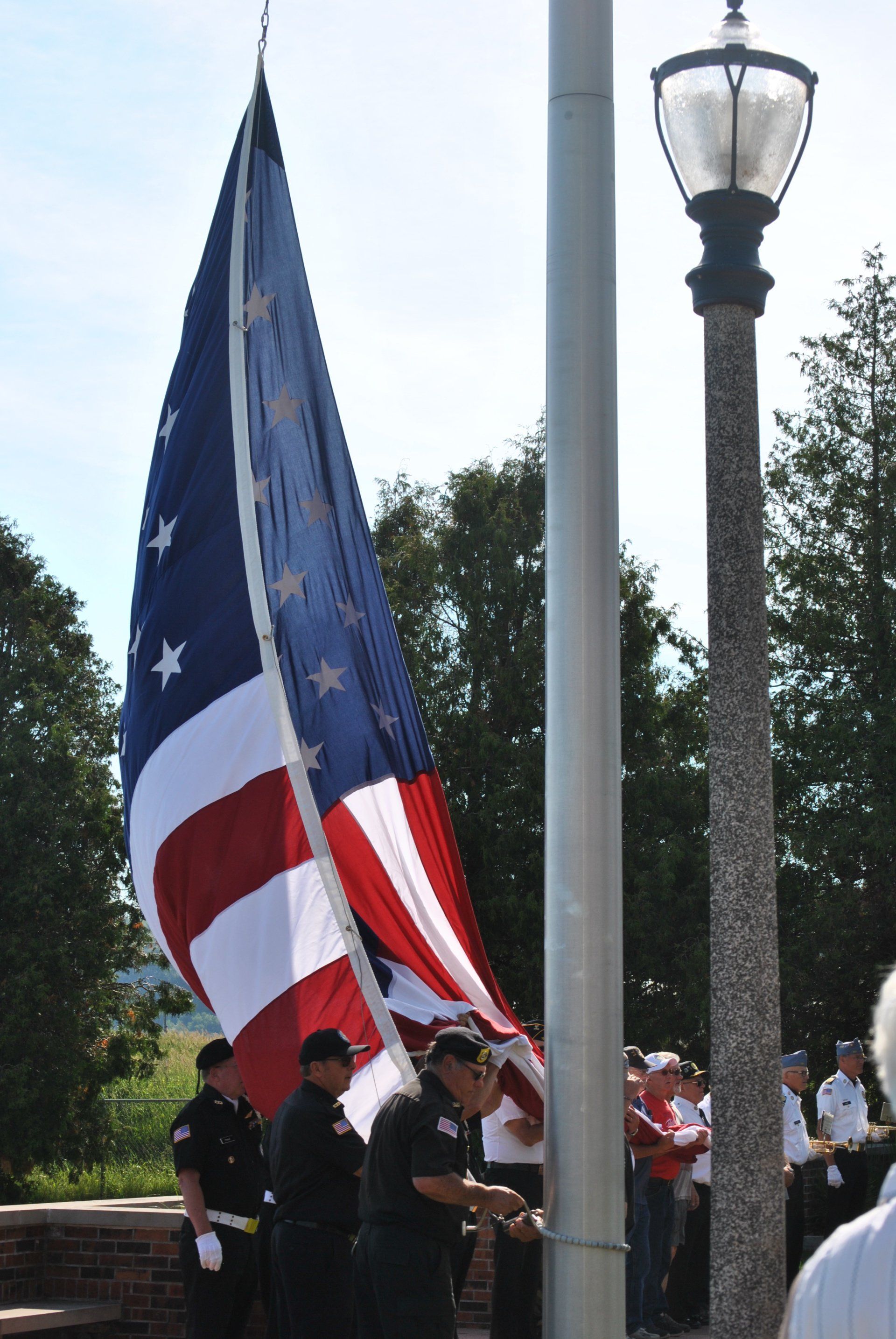 A group of men are raising an american flag