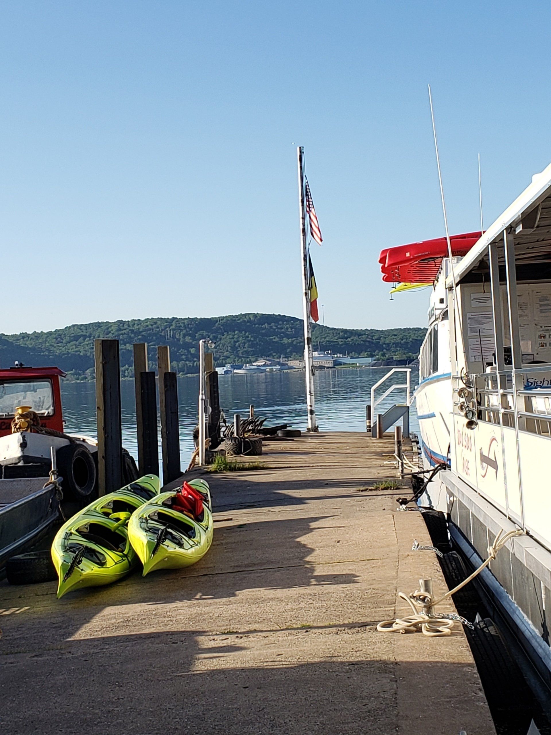 Two yellow kayaks are sitting on a dock next to a boat.