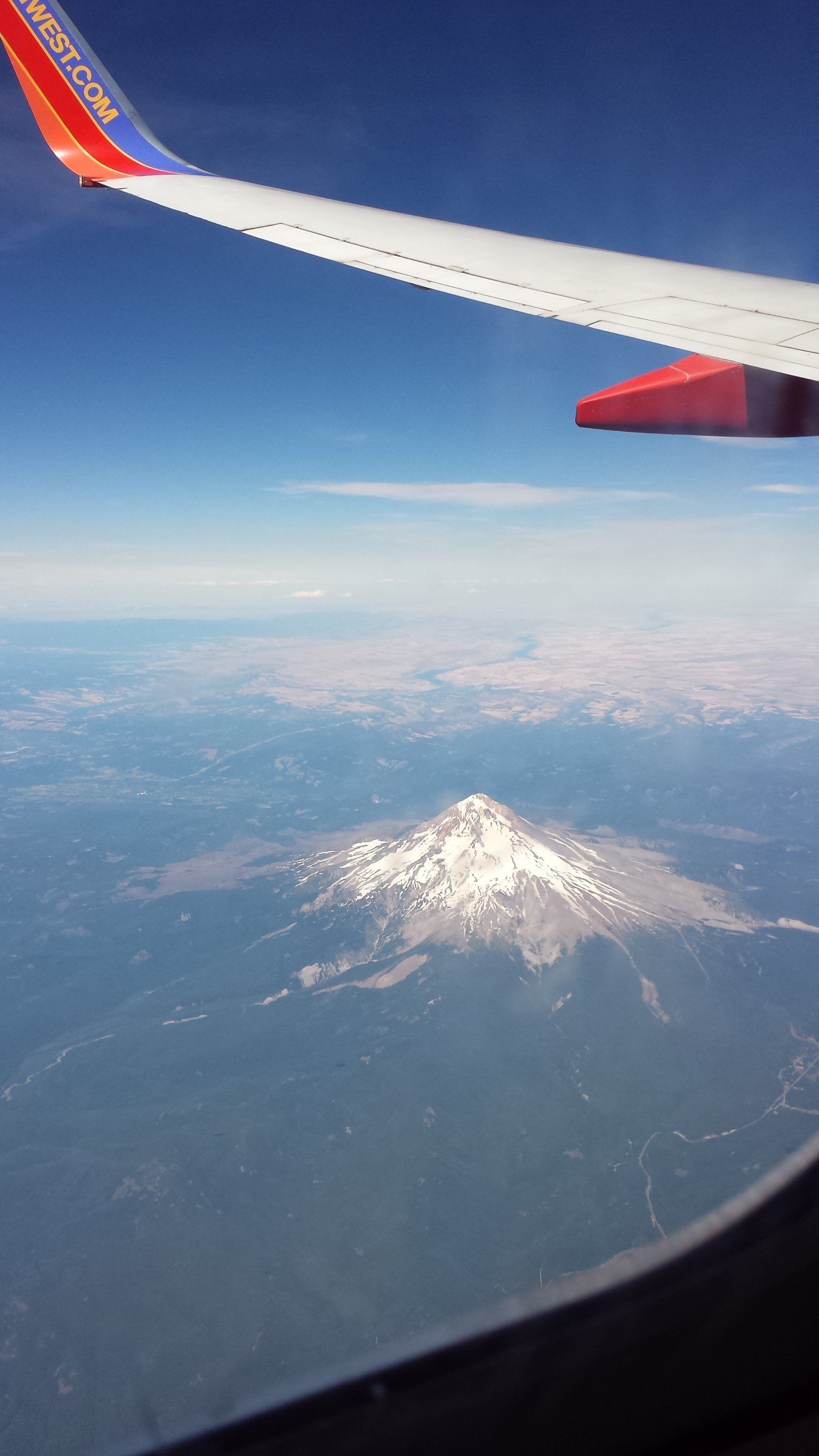 A southwest airlines plane is flying over a mountain