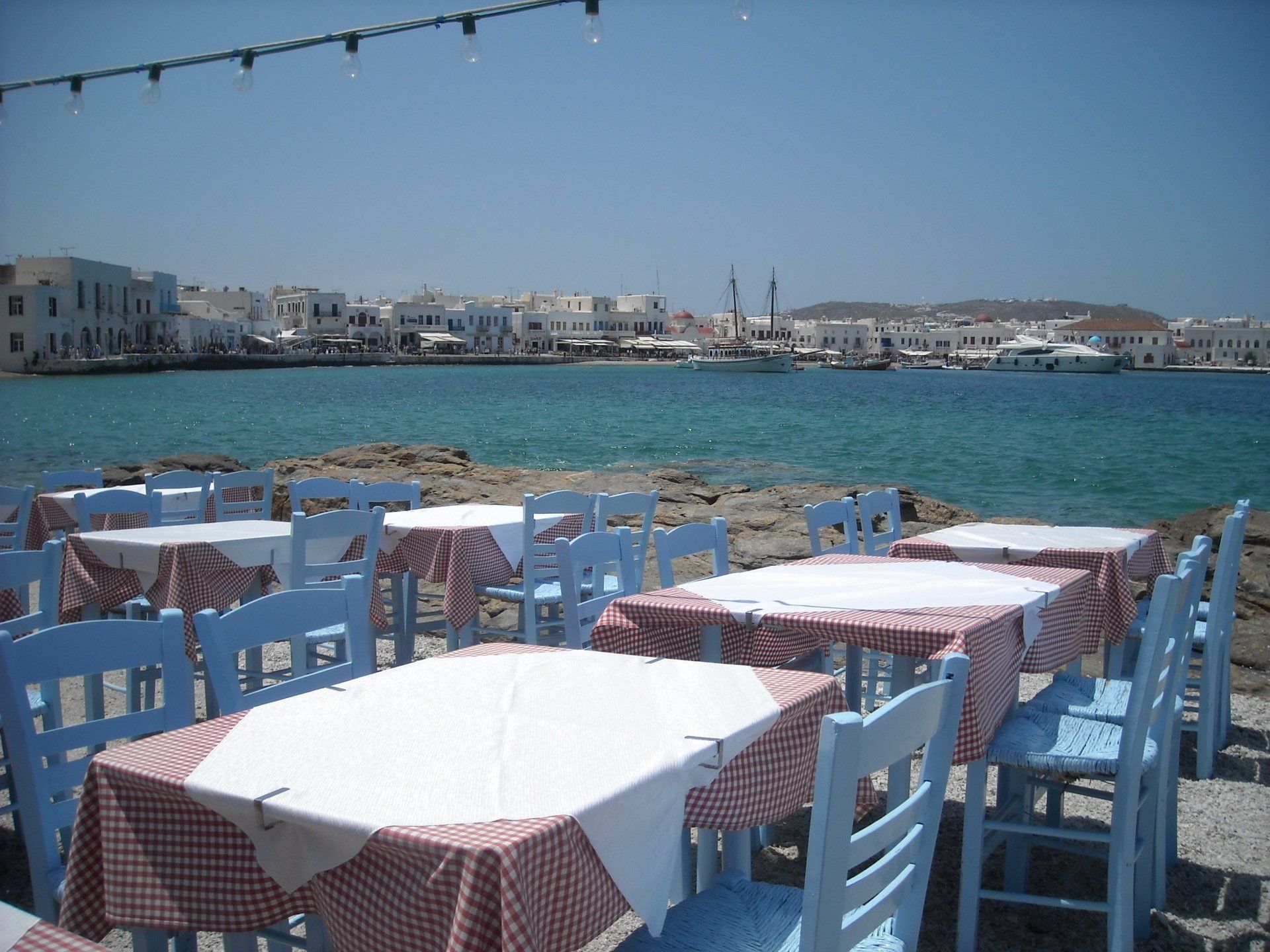Tables and chairs are set up in front of a body of water