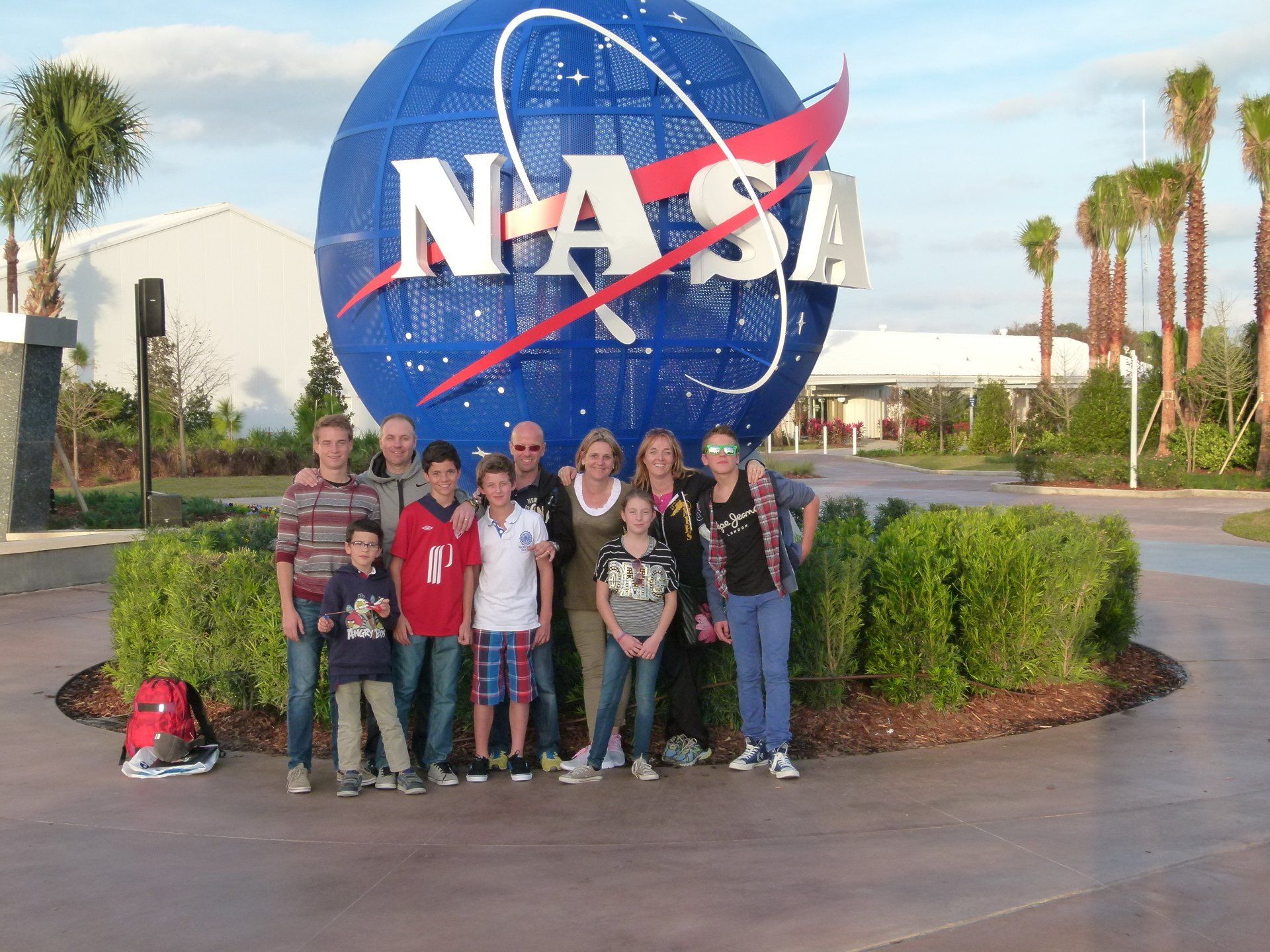 A group of people pose in front of a nasa sign