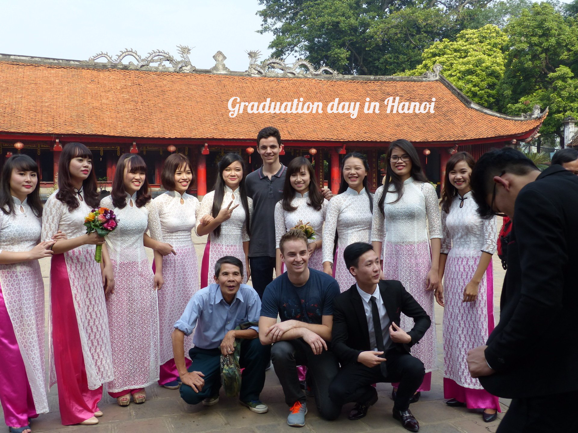 A group of people posing for a picture on graduation day in hanoi.