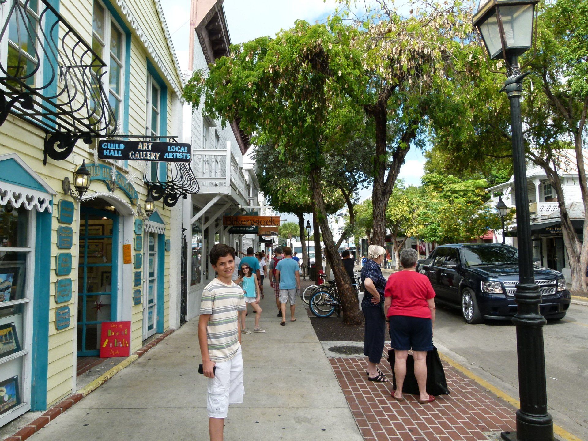 People walking down a street with a sign that says gallery on it
