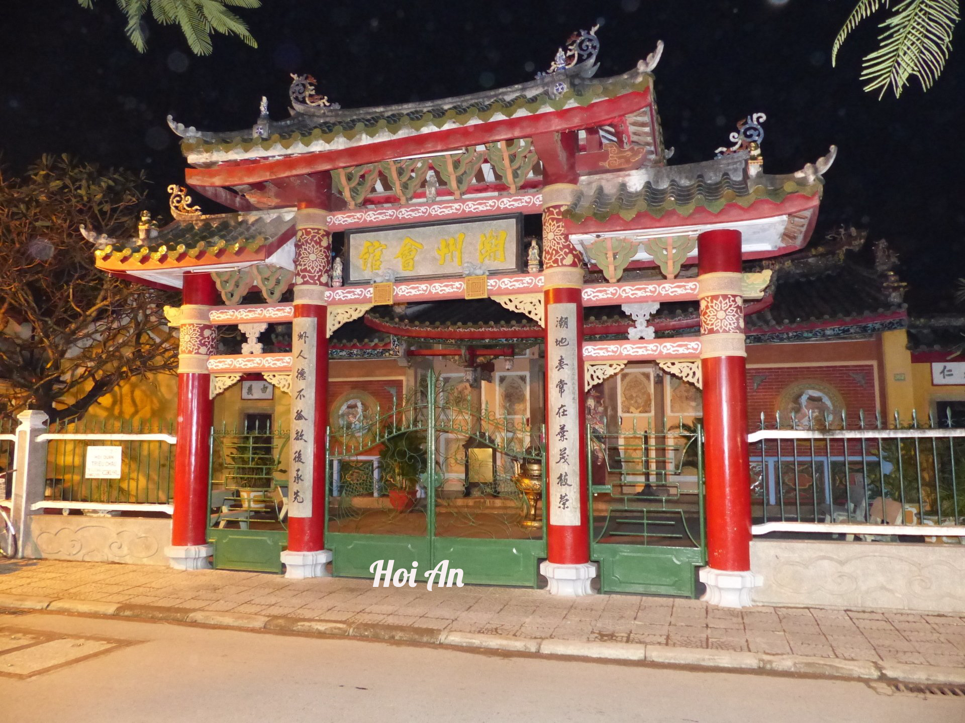 The entrance to a chinese temple has a sign that says hoi an