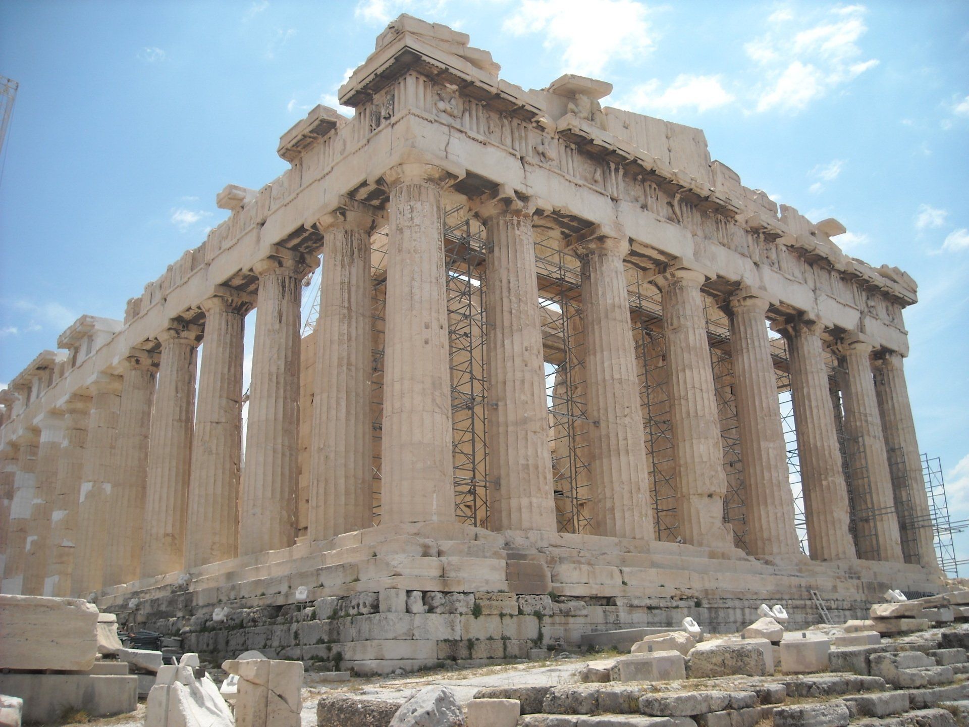 A very old building with columns and a blue sky in the background