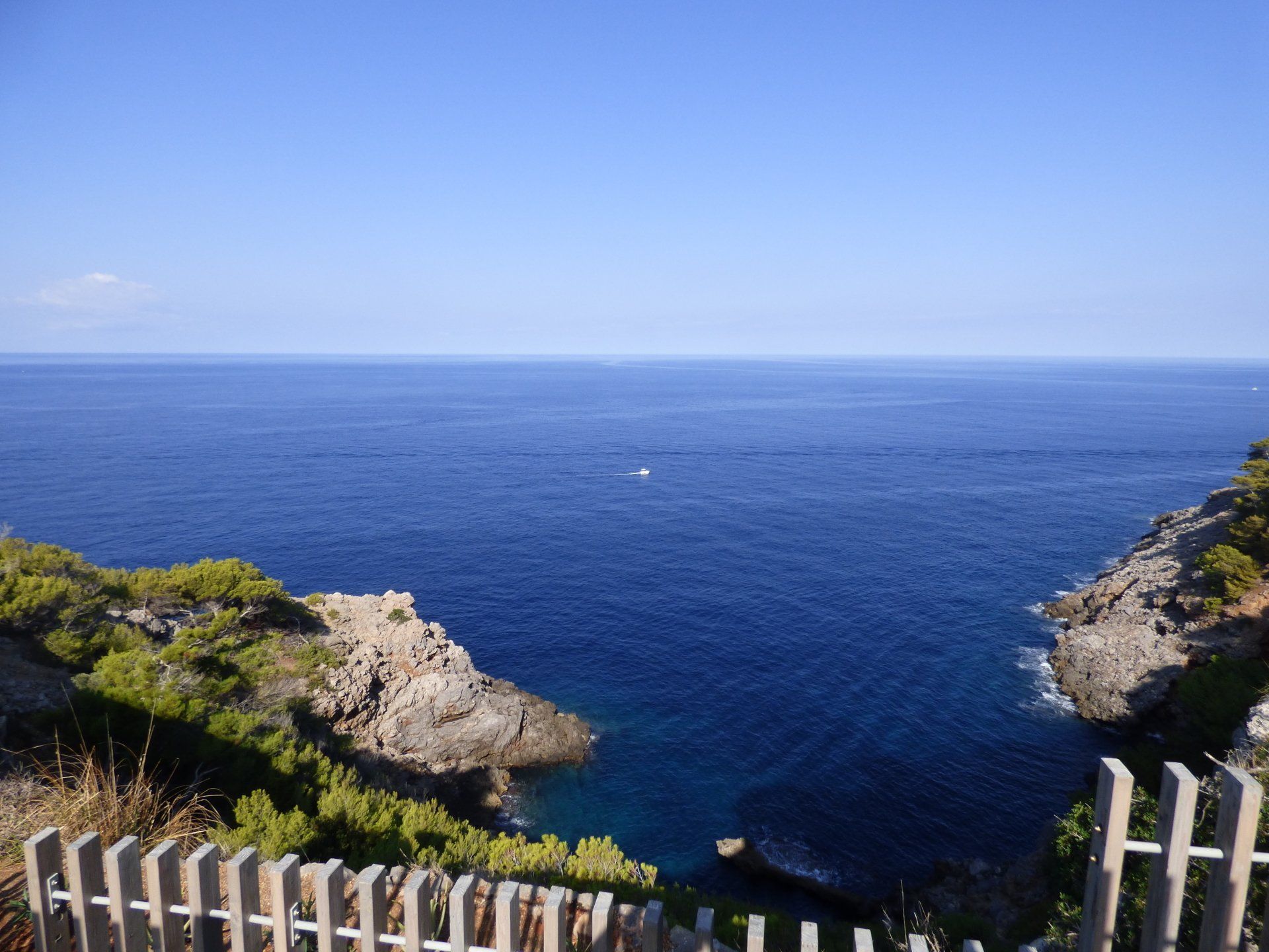 A wooden fence surrounds a cliff overlooking the ocean