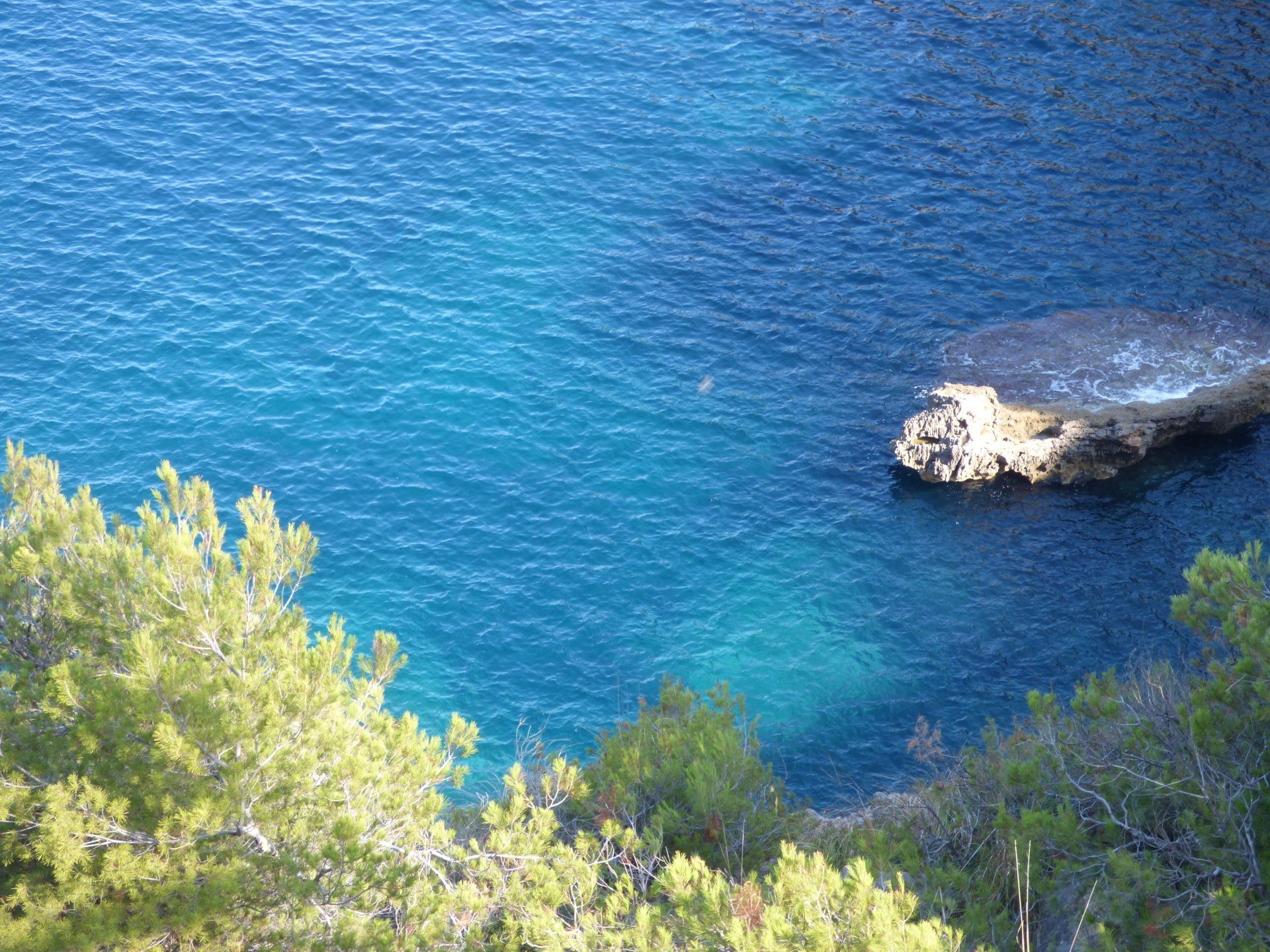 A large rock in the middle of a body of water