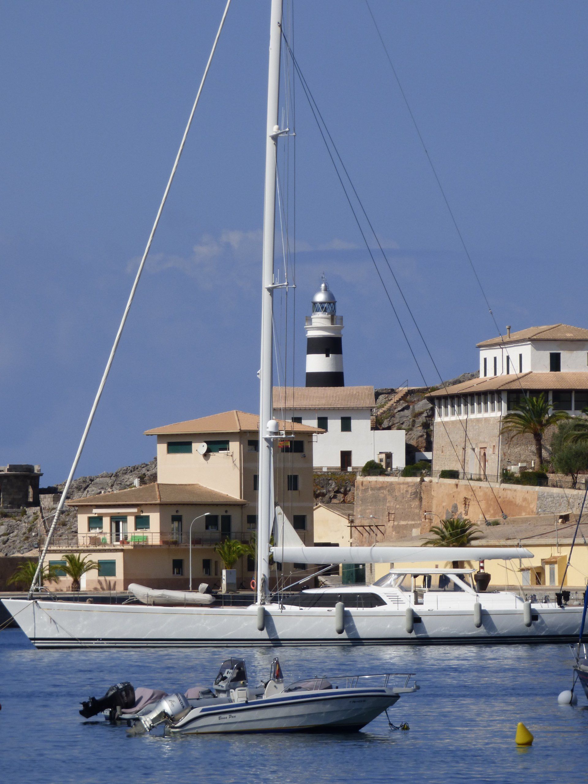 A boat in the water with a lighthouse in the background
