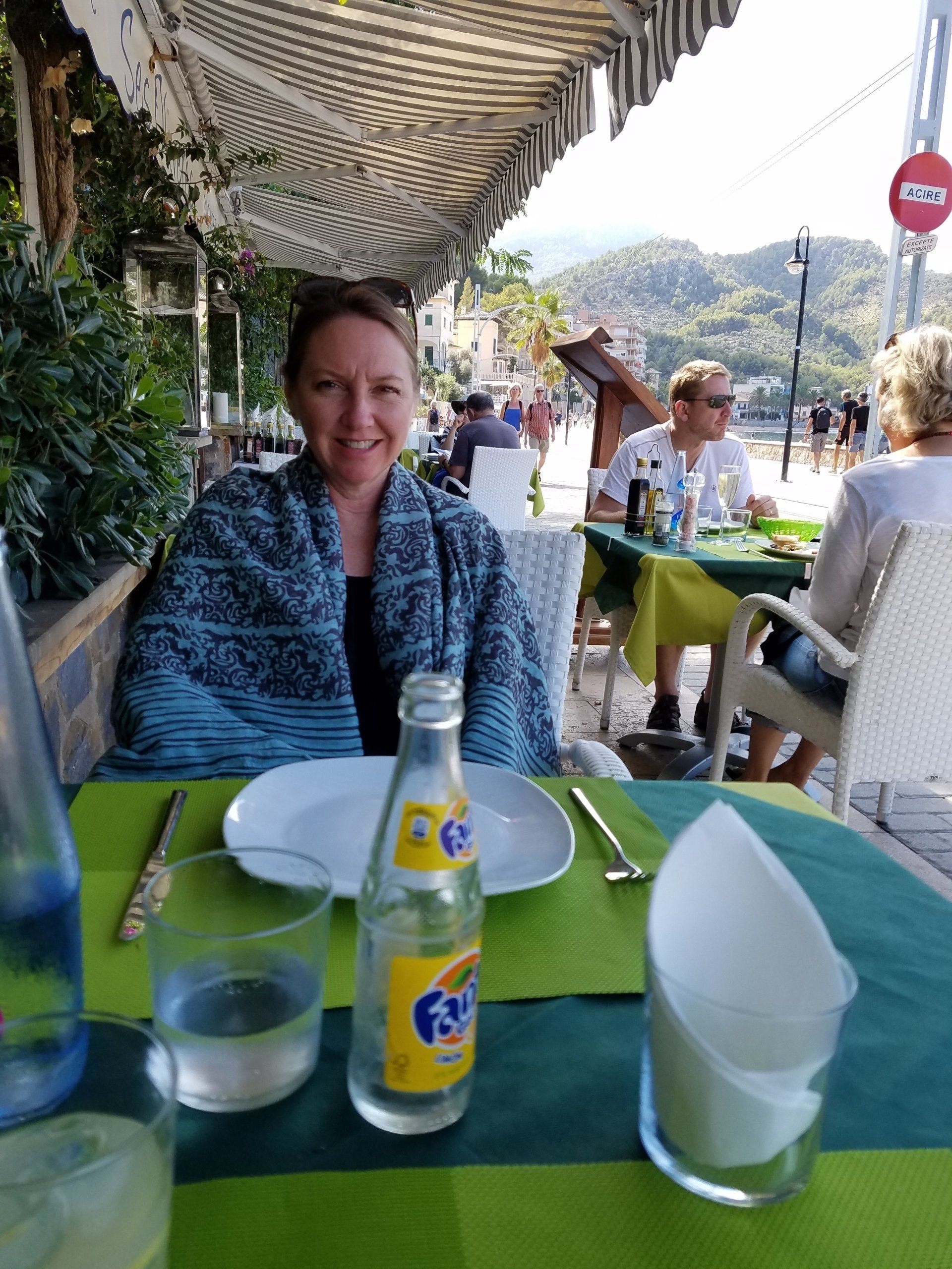 A woman is sitting at a table with a fanta bottle on it