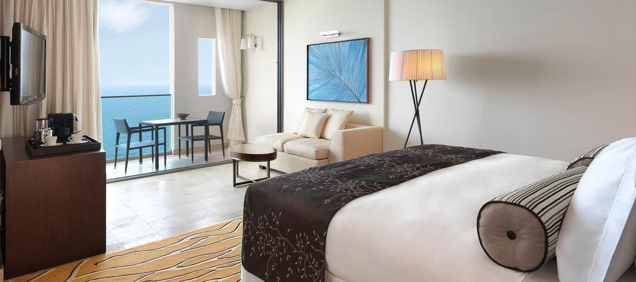 A hotel room with a bed , couch , table and television.