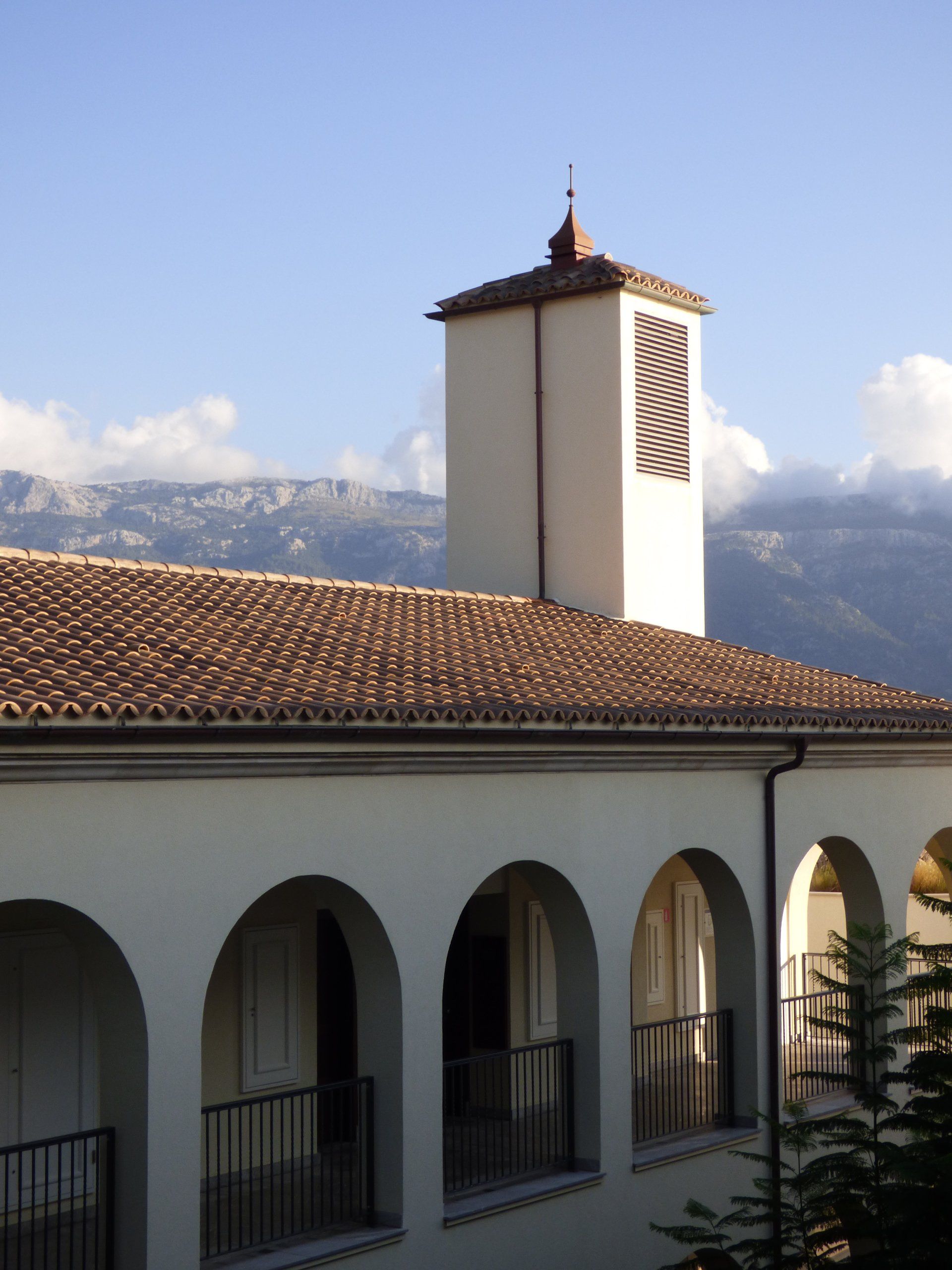 A white building with arches and a tower on top