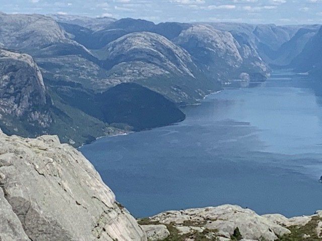 A large body of water surrounded by mountains and trees.