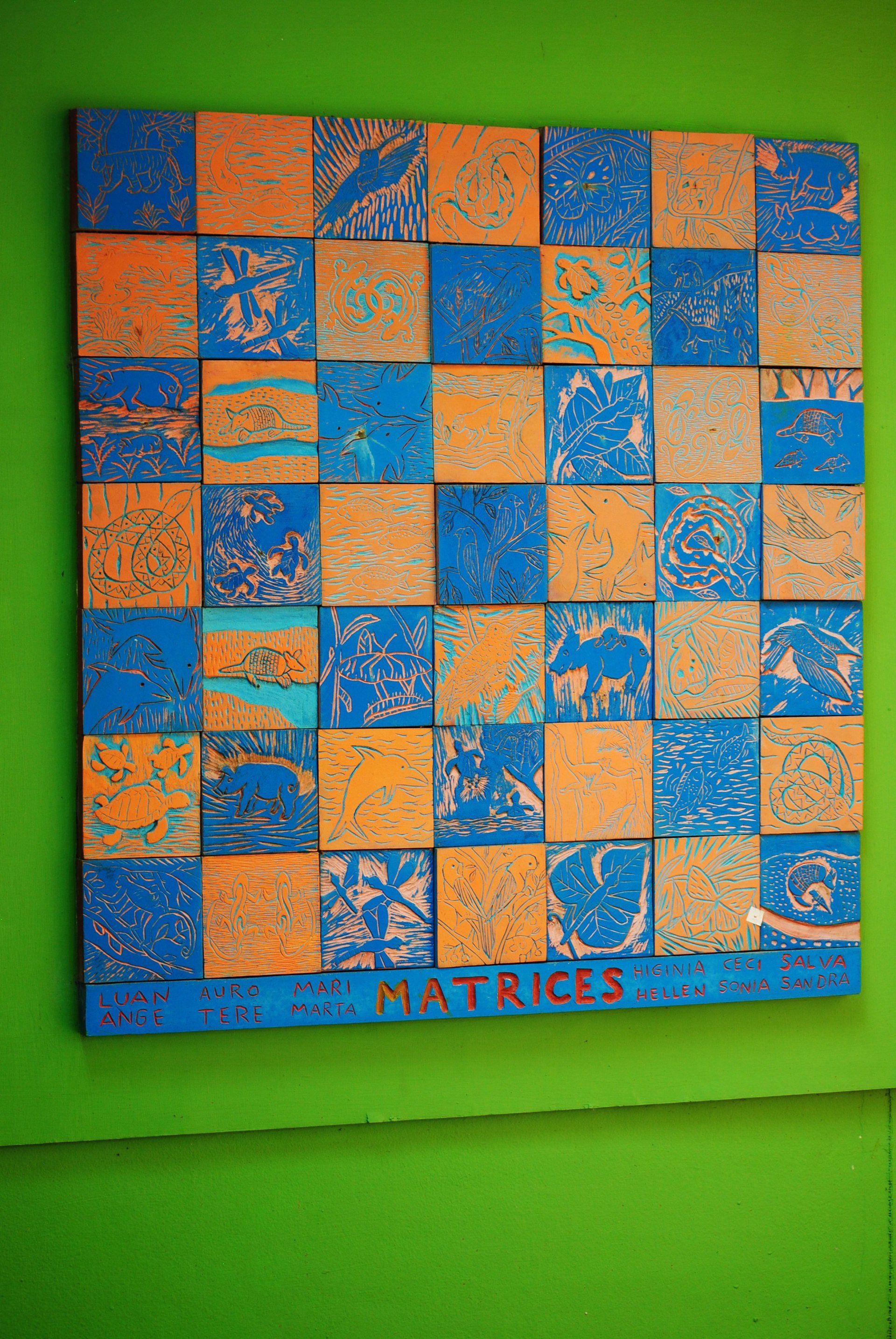 A blue and orange checkered painting is hanging on a green wall.