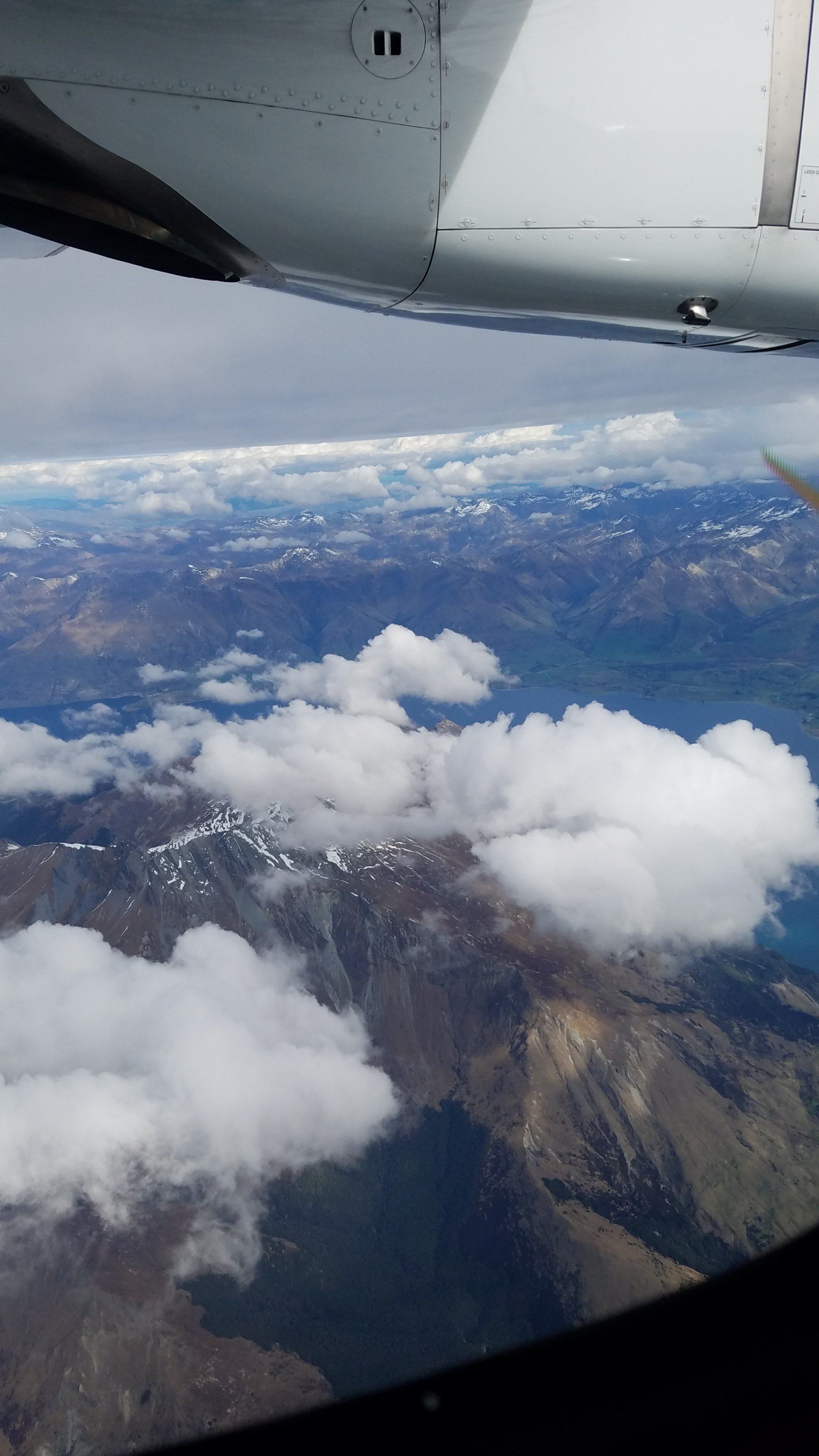 A view of mountains and clouds from an airplane window
