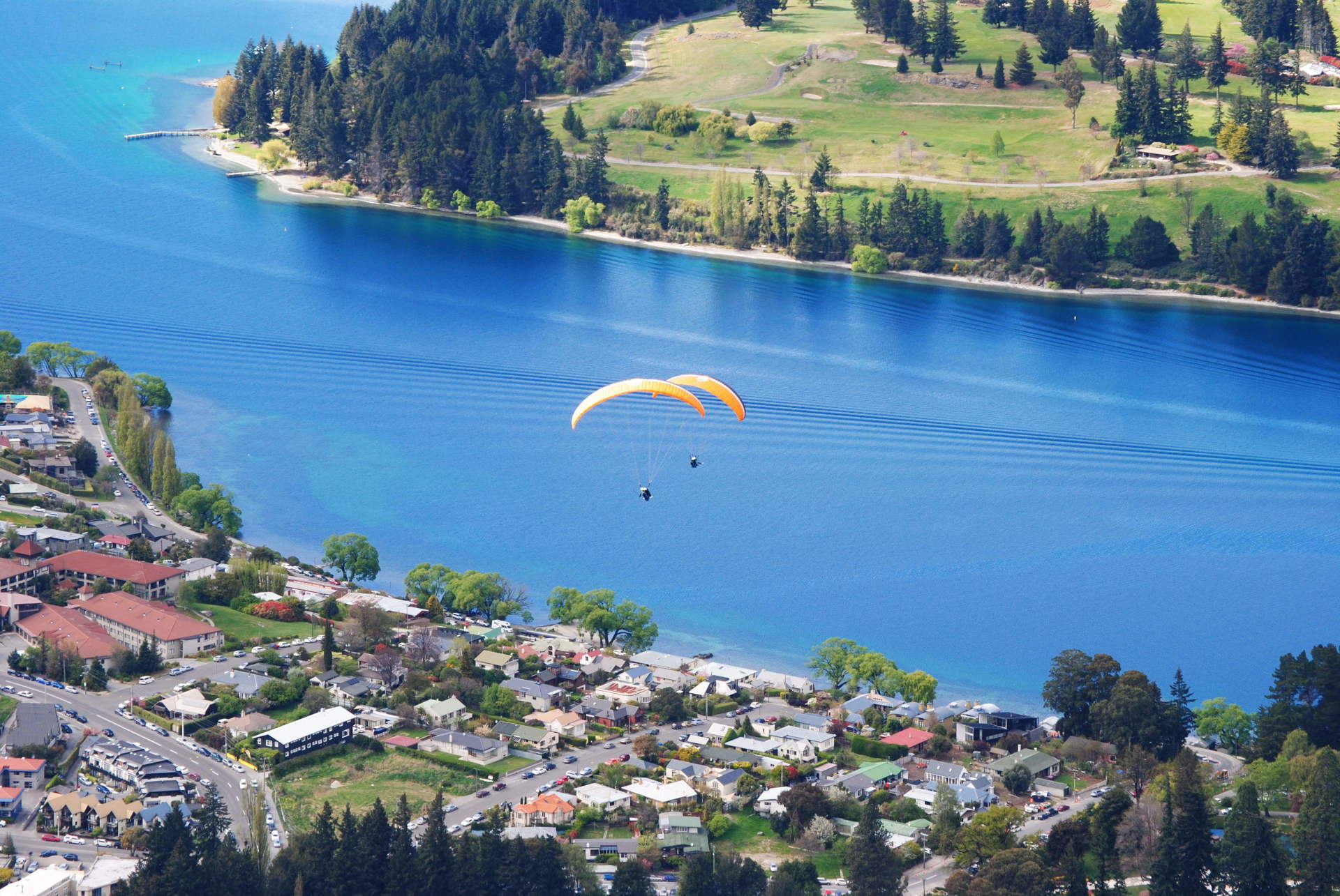 A paraglider is flying over a body of water