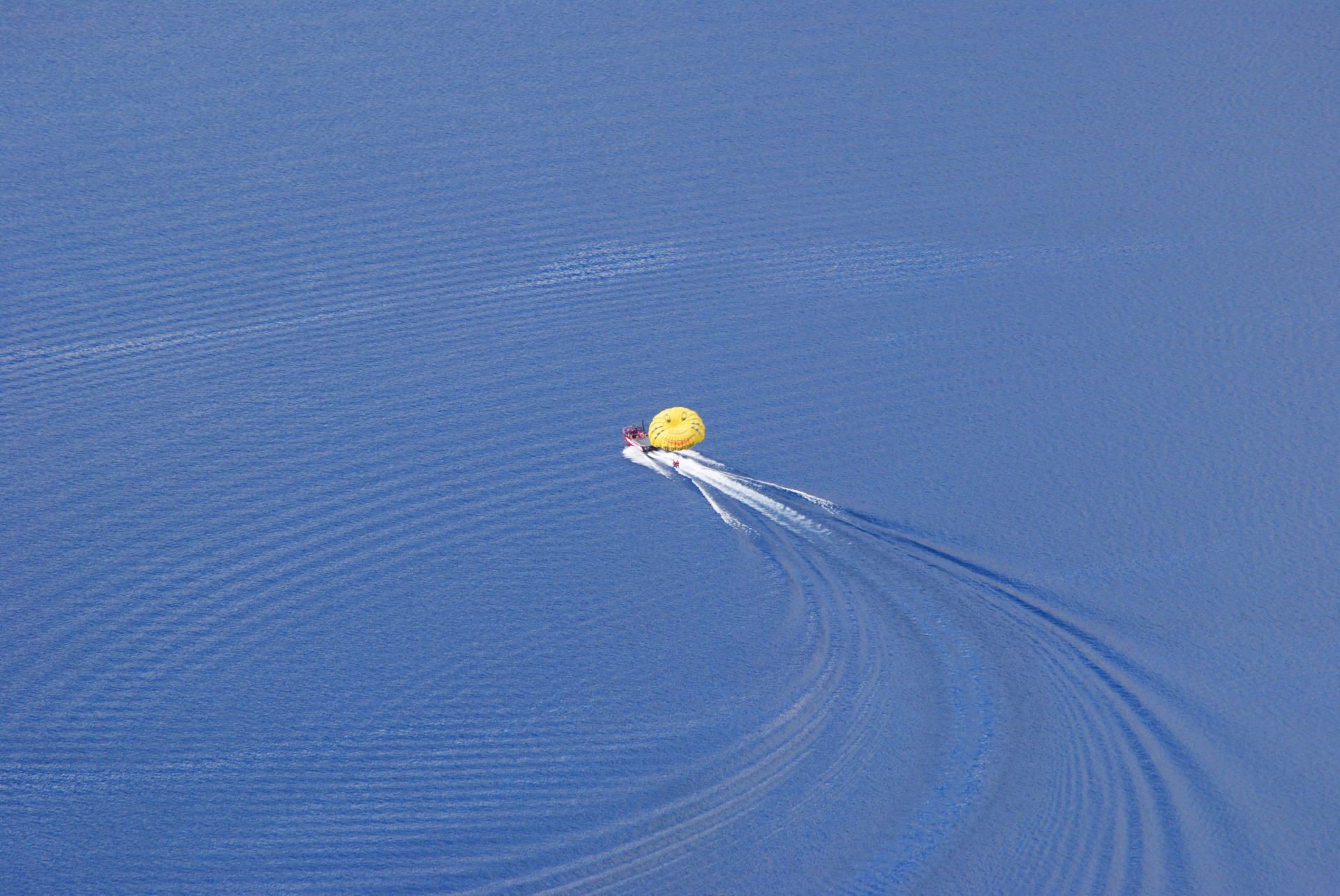 A yellow balloon is floating on top of a body of water.