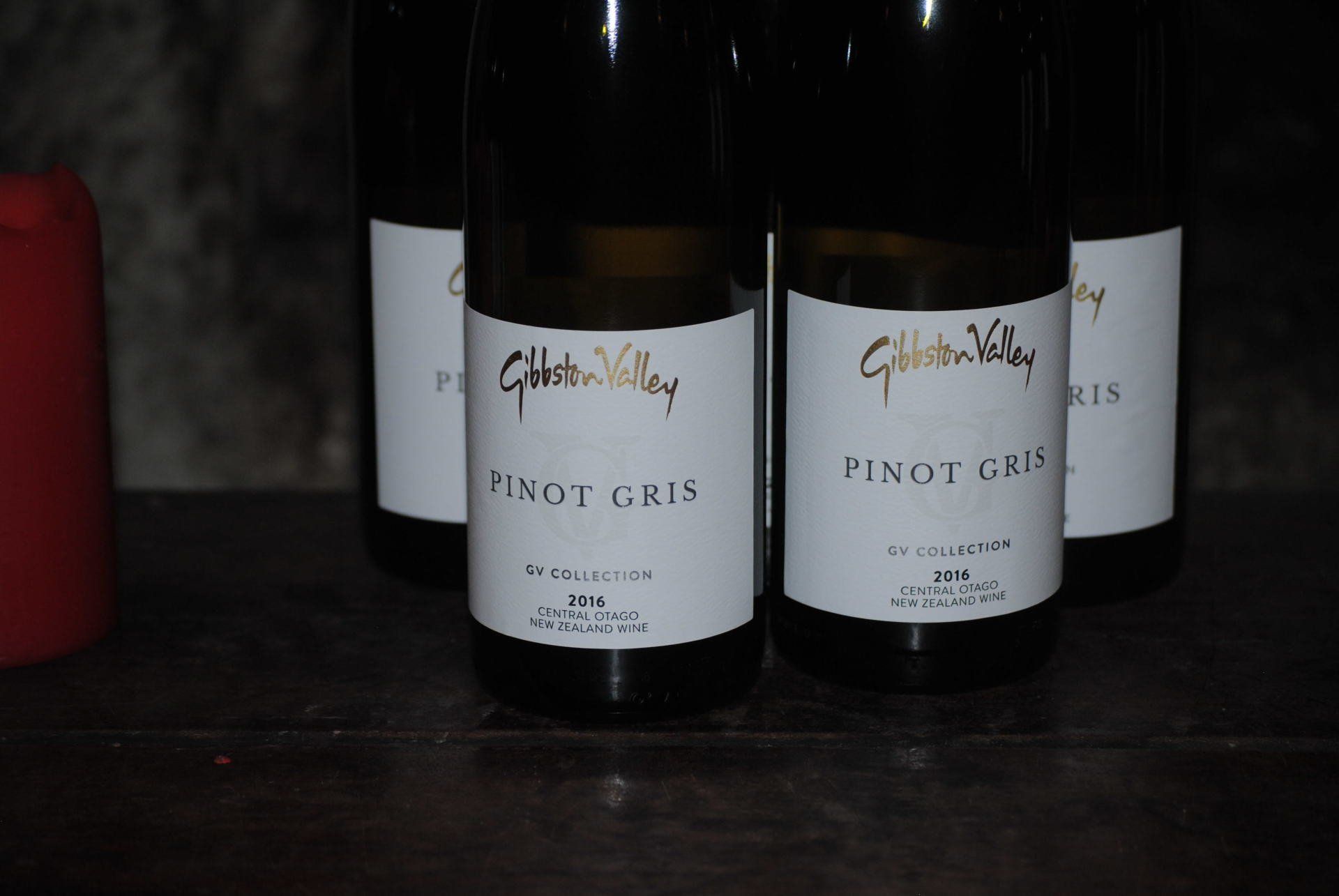Three bottles of pinot gris sit on a table