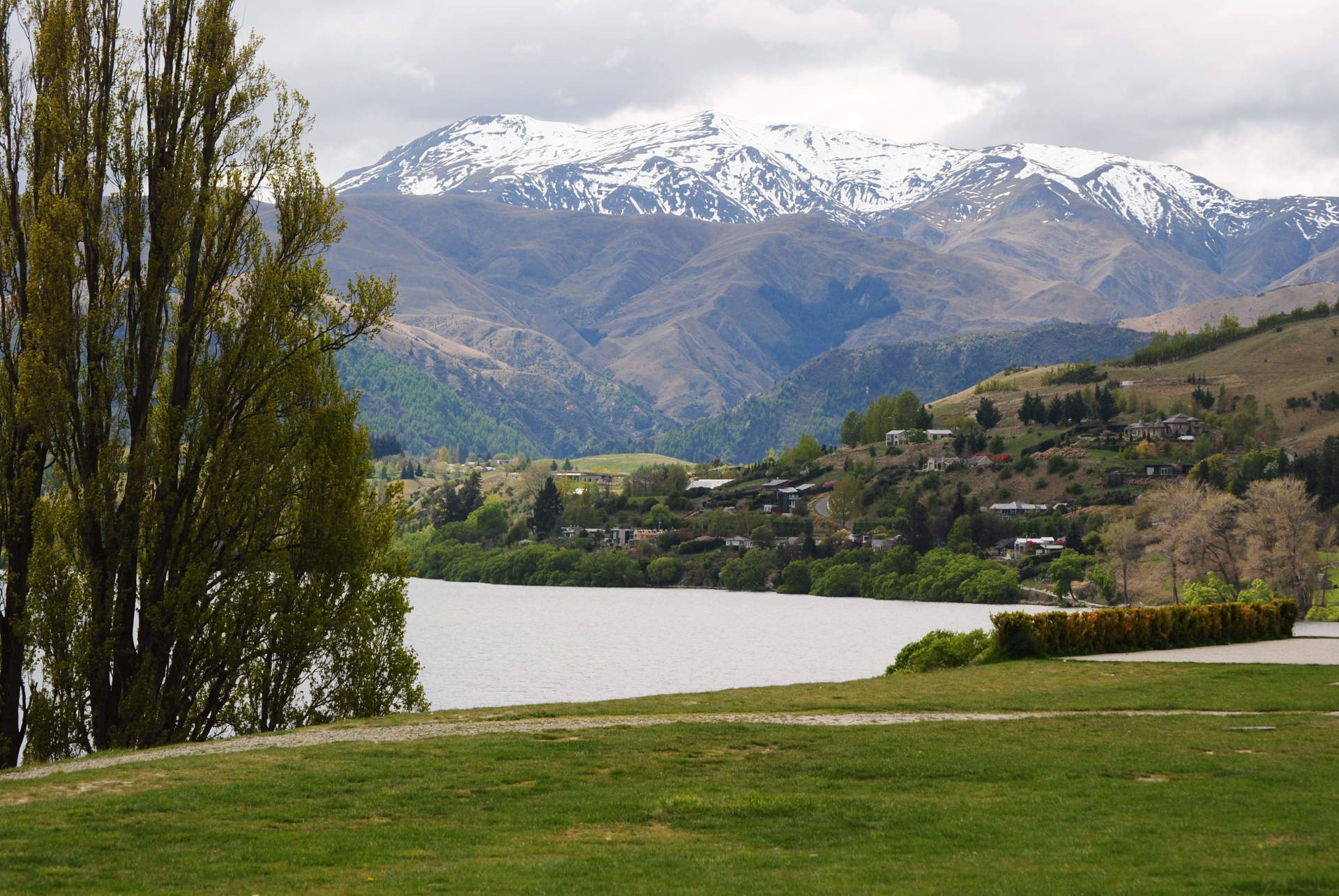 A lake with mountains in the background and trees in the foreground