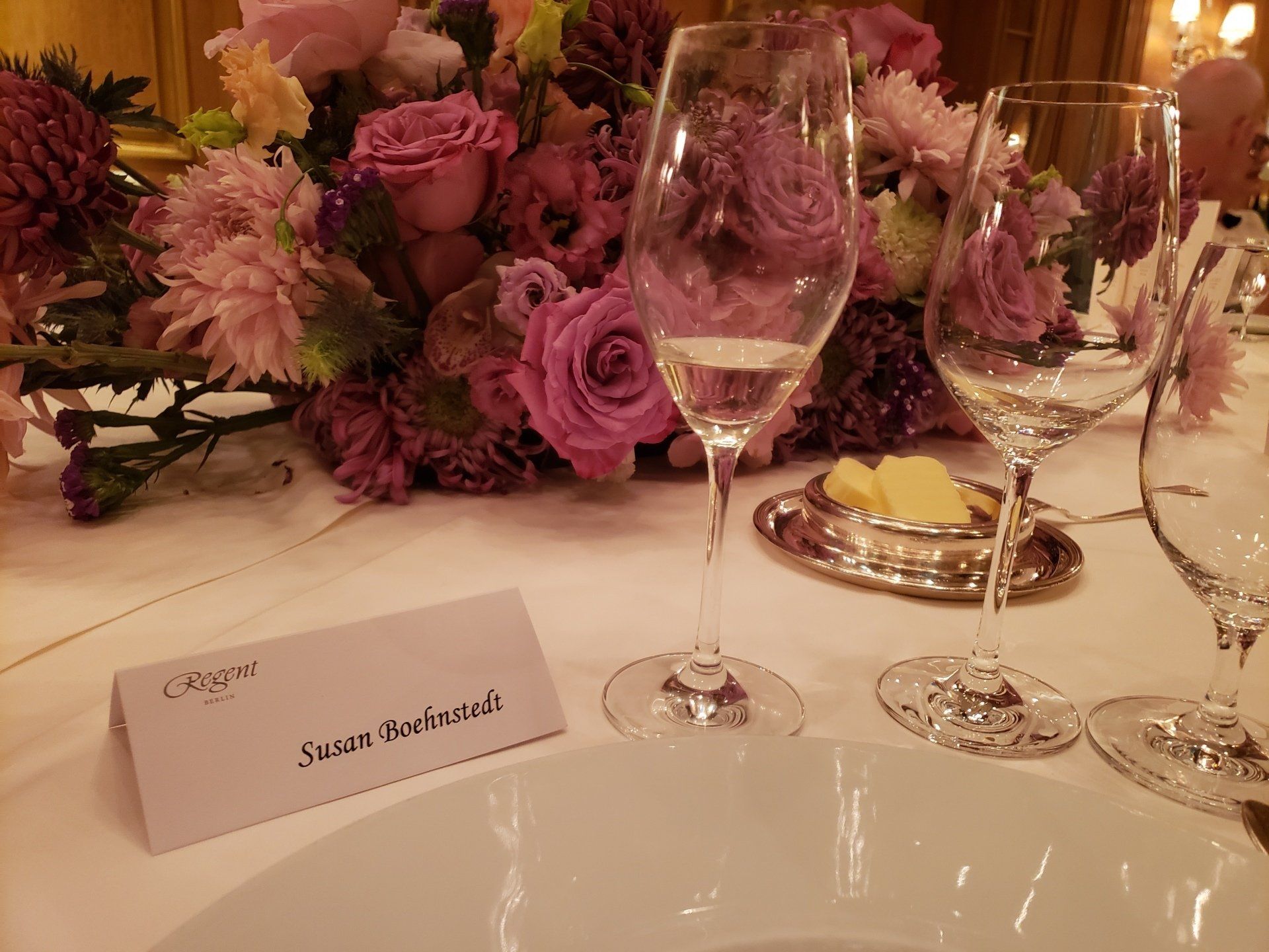 A table with purple flowers and wine glasses on it