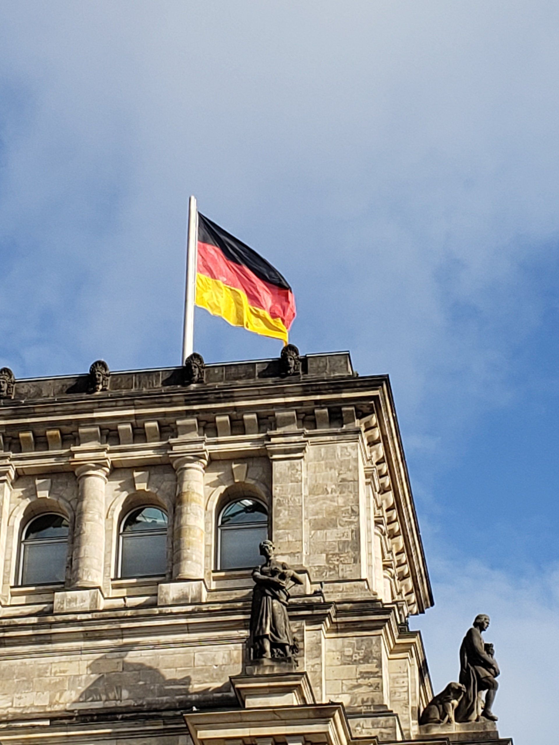 A german flag is flying on top of a building.