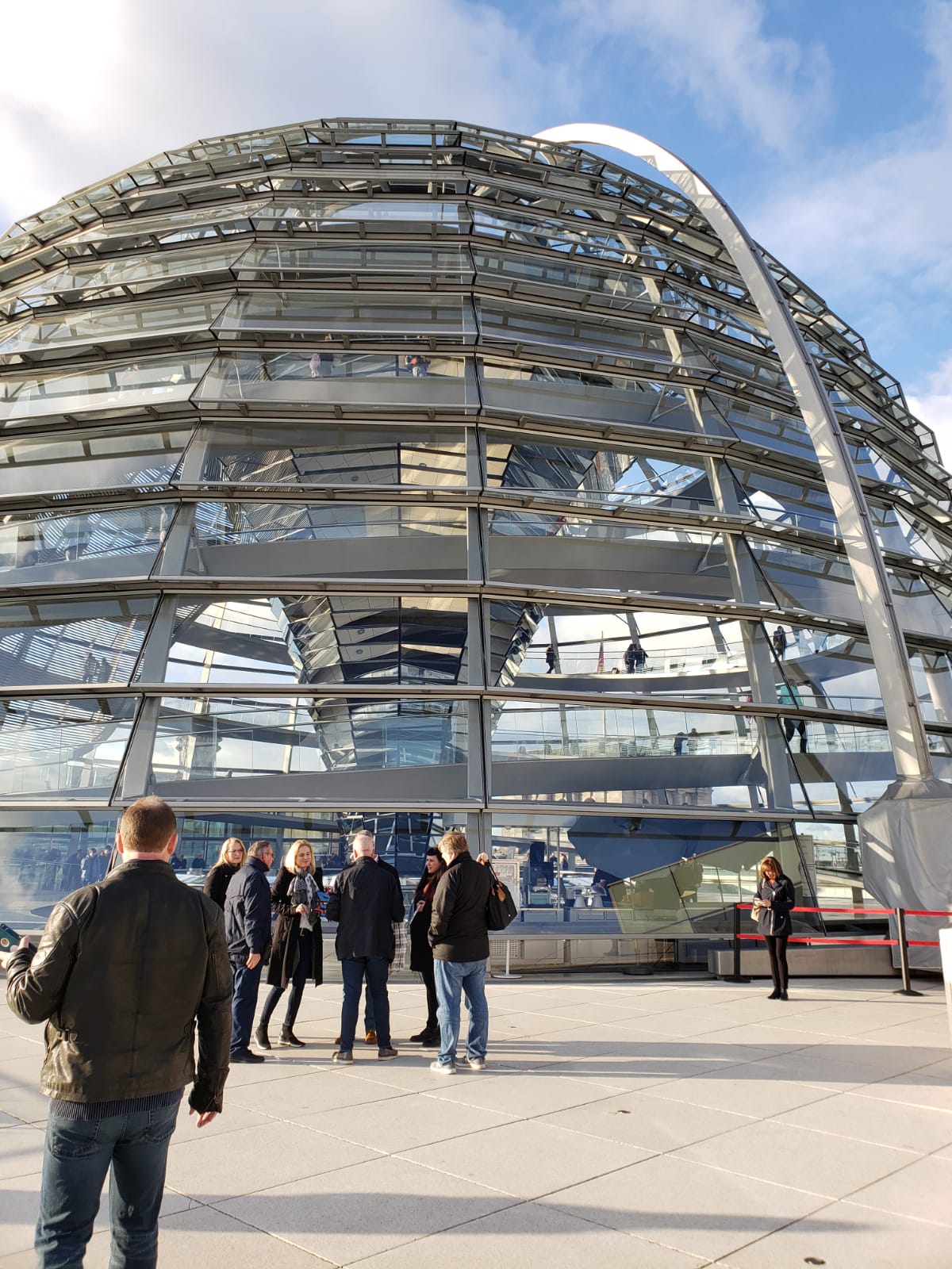 A group of people are standing in front of a dome shaped building.