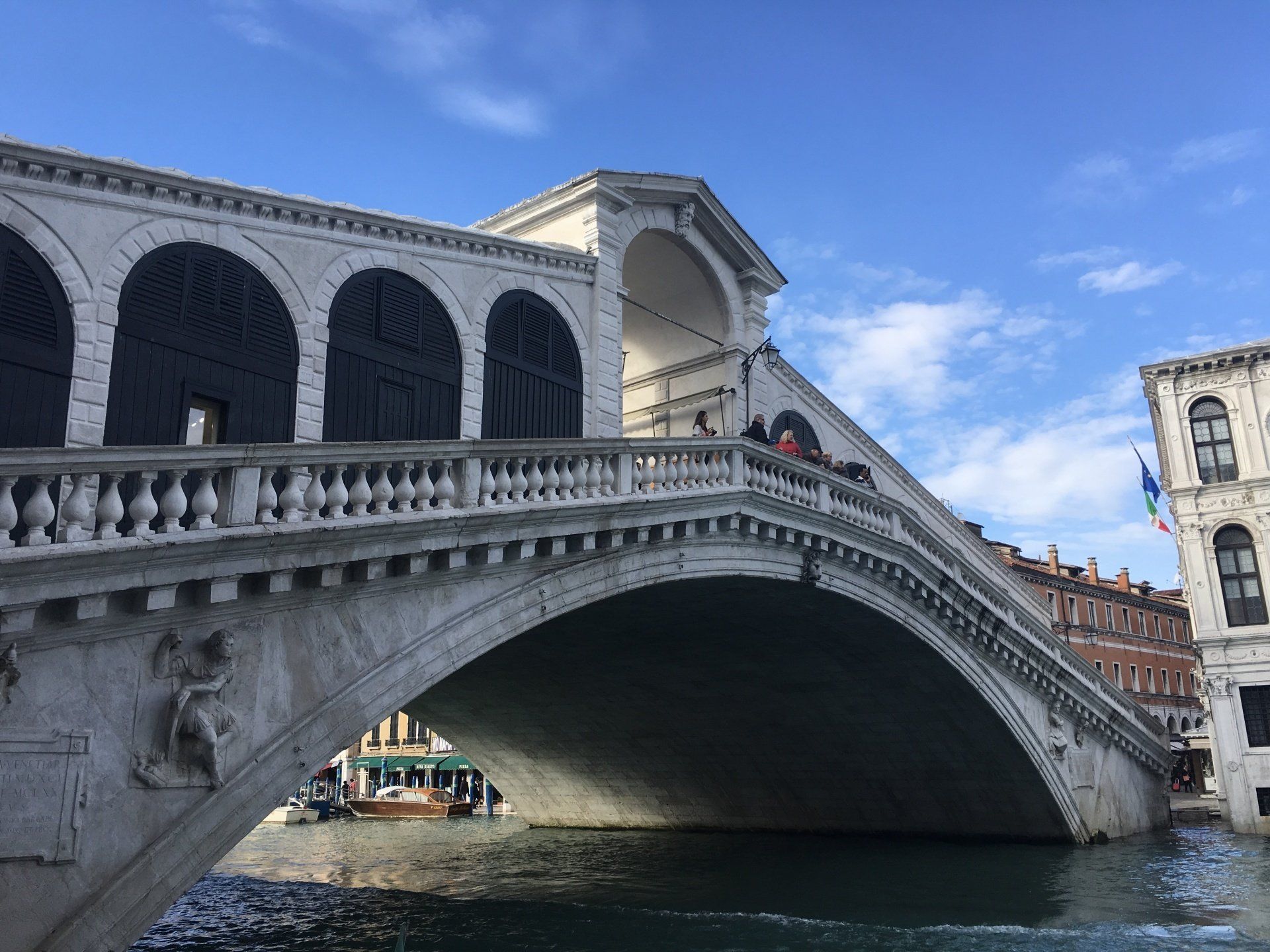 A bridge over a body of water with a building in the background.