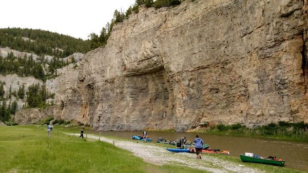 A group of people are standing next to a river.