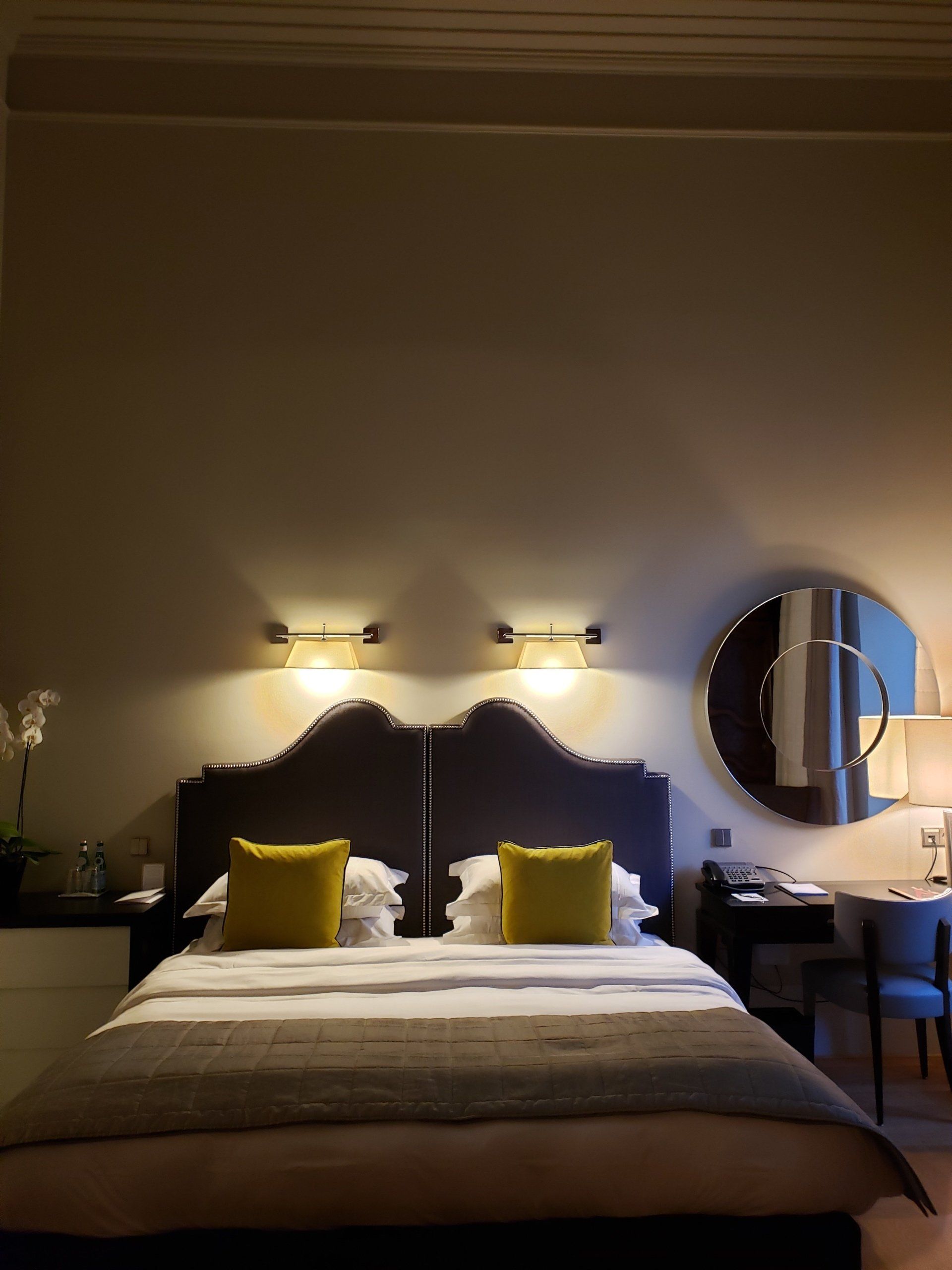 A hotel room with a bed and a mirror