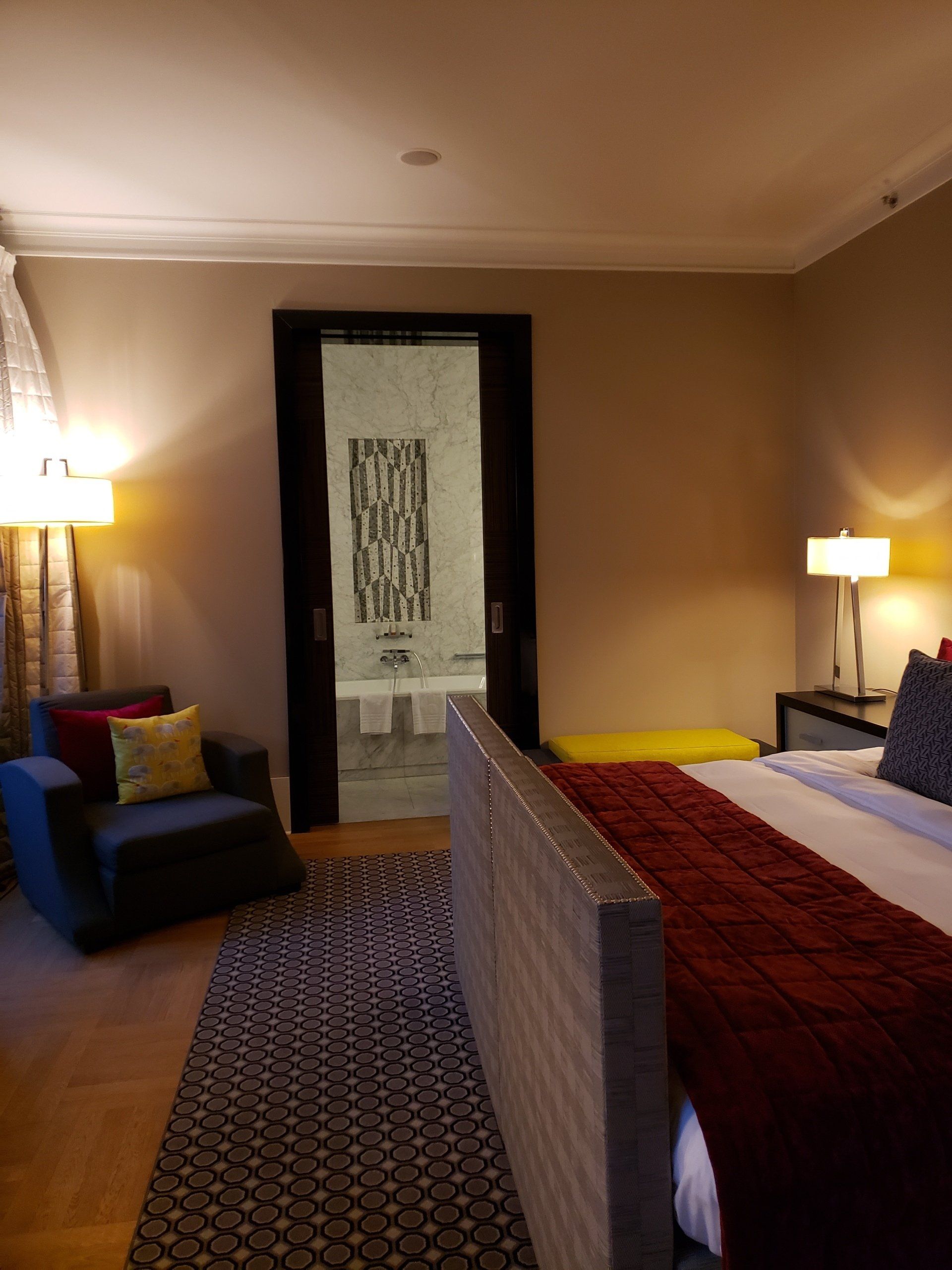 A bedroom with a king size bed and a chair