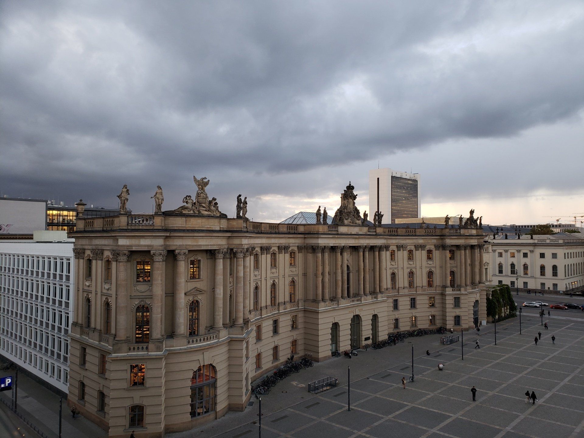 An aerial view of a large building with a cloudy sky in the background.