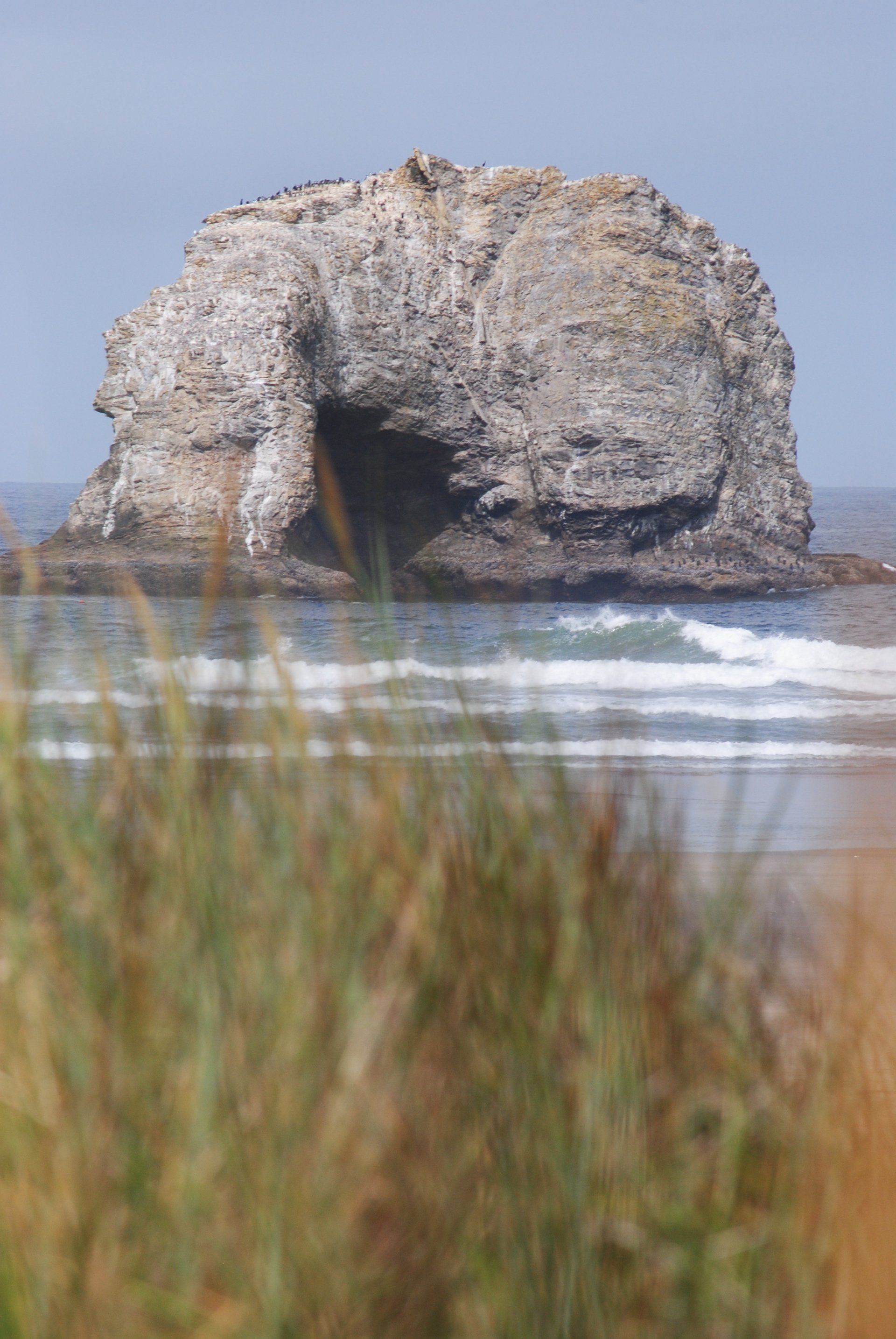 There is a large rock in the middle of the ocean.