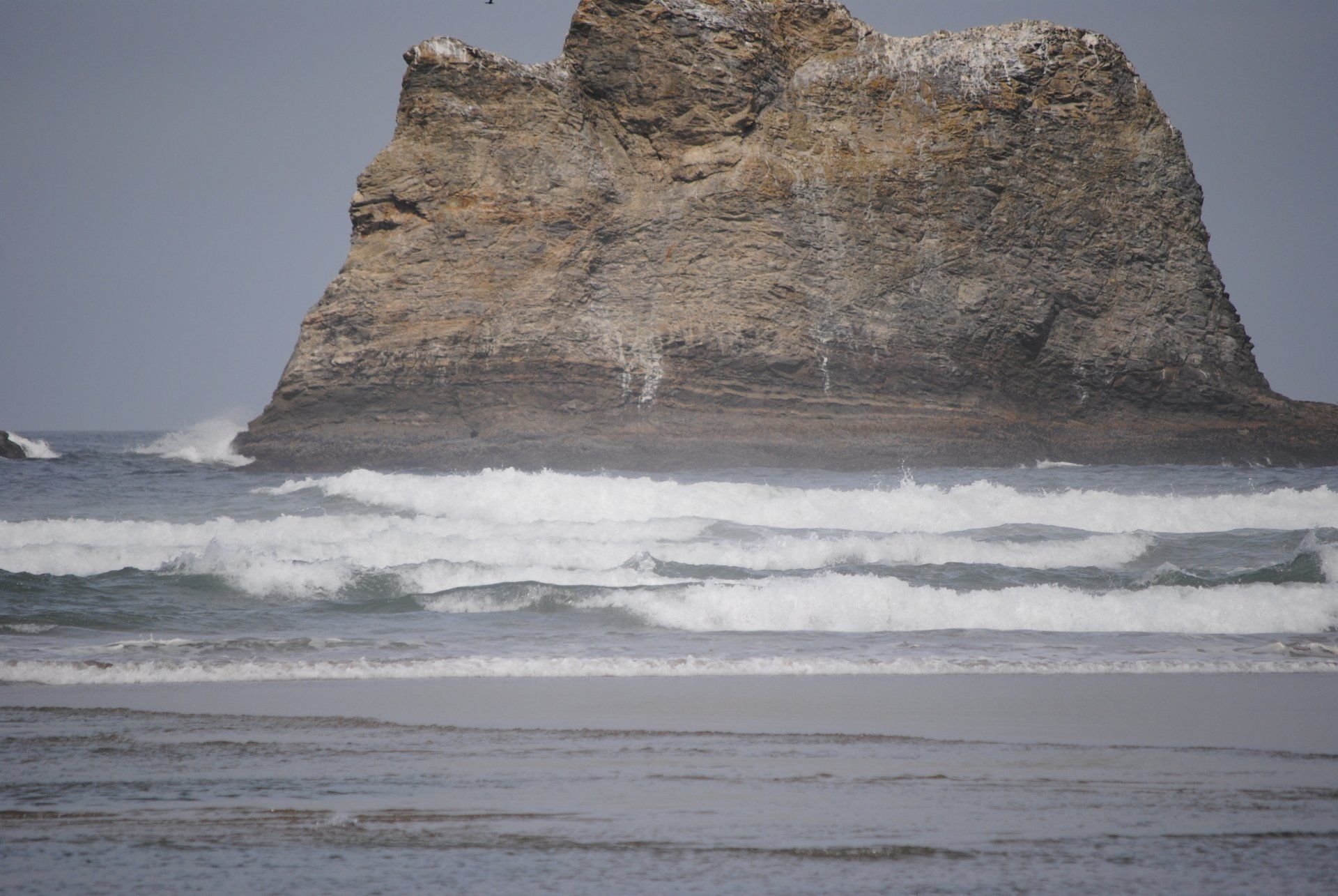 A large rock in the middle of a body of water