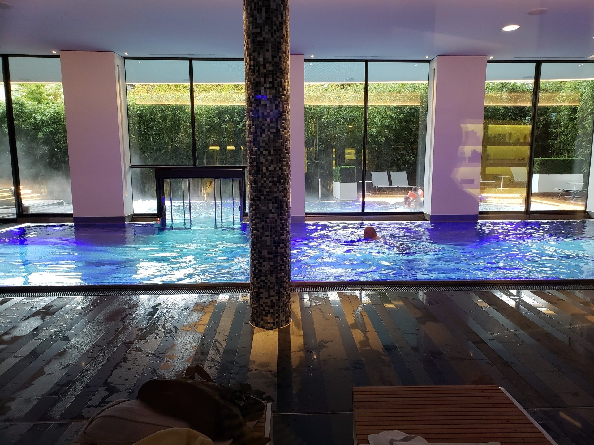 A person is swimming in a large indoor pool